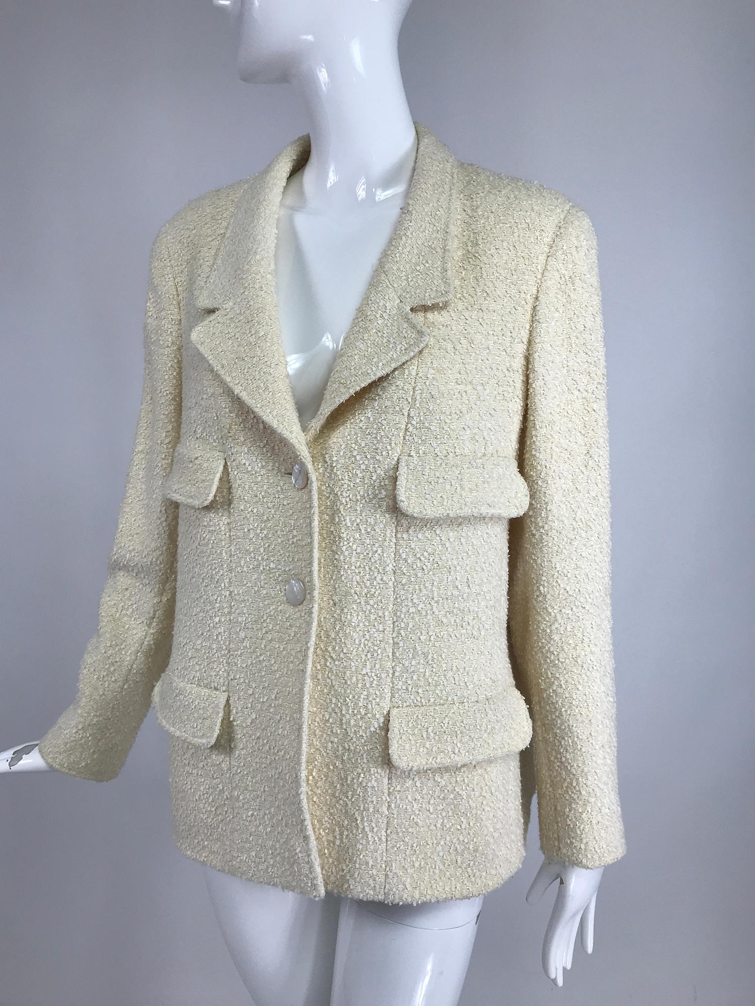 Chanel Cream boulce 4 pocket jacket 1998C with mother of pearl logo buttons. Hip length jacket with 4 flap pockets, 2 working. Low V neckline with notched lapel collar. Long sleeves have single button cuffs. Lined in white silk. Marked size 42. 
   