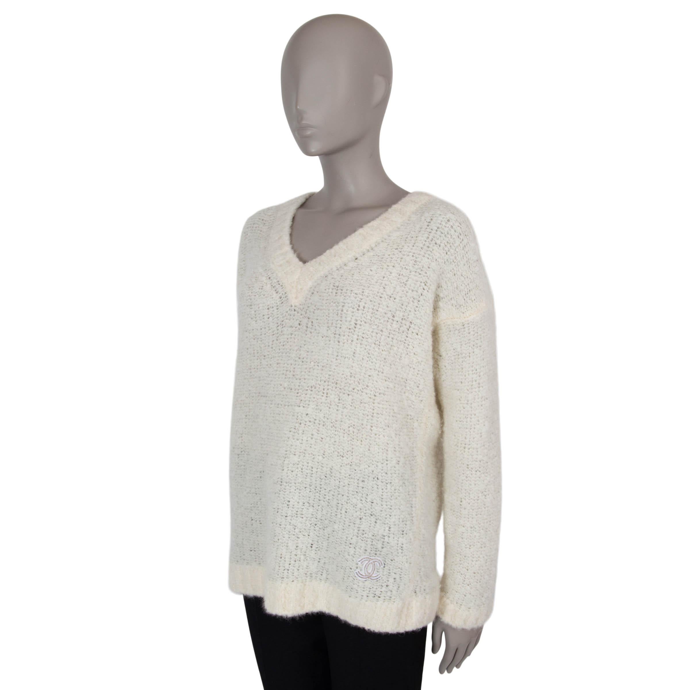 Dieser 100% authentische Chanel-Pullover aus cremefarbenem Fuzzi-Bouclé-Kaschmir (100%) strahlt kuschelige Eleganz aus. Die Oversized-Silhouette mit überschnittenen Schultern, tiefem V-Ausschnitt und klobigen Rippstrickbündchen sorgt für einen