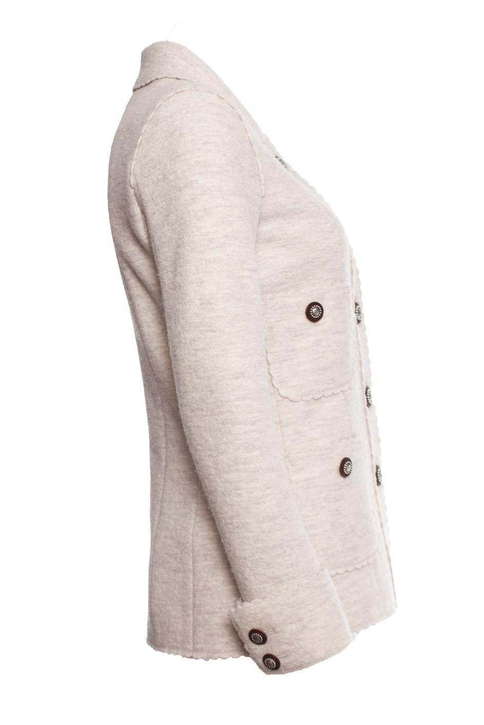 Chanel, veste en laine de couleur crème avec boutons argentés bruns. L'article comporte 4 poches sur le devant et présente une finition romantique avec des bords arrondis. L'article est en très bon état mais présente un petit trou de mite au dos.

•