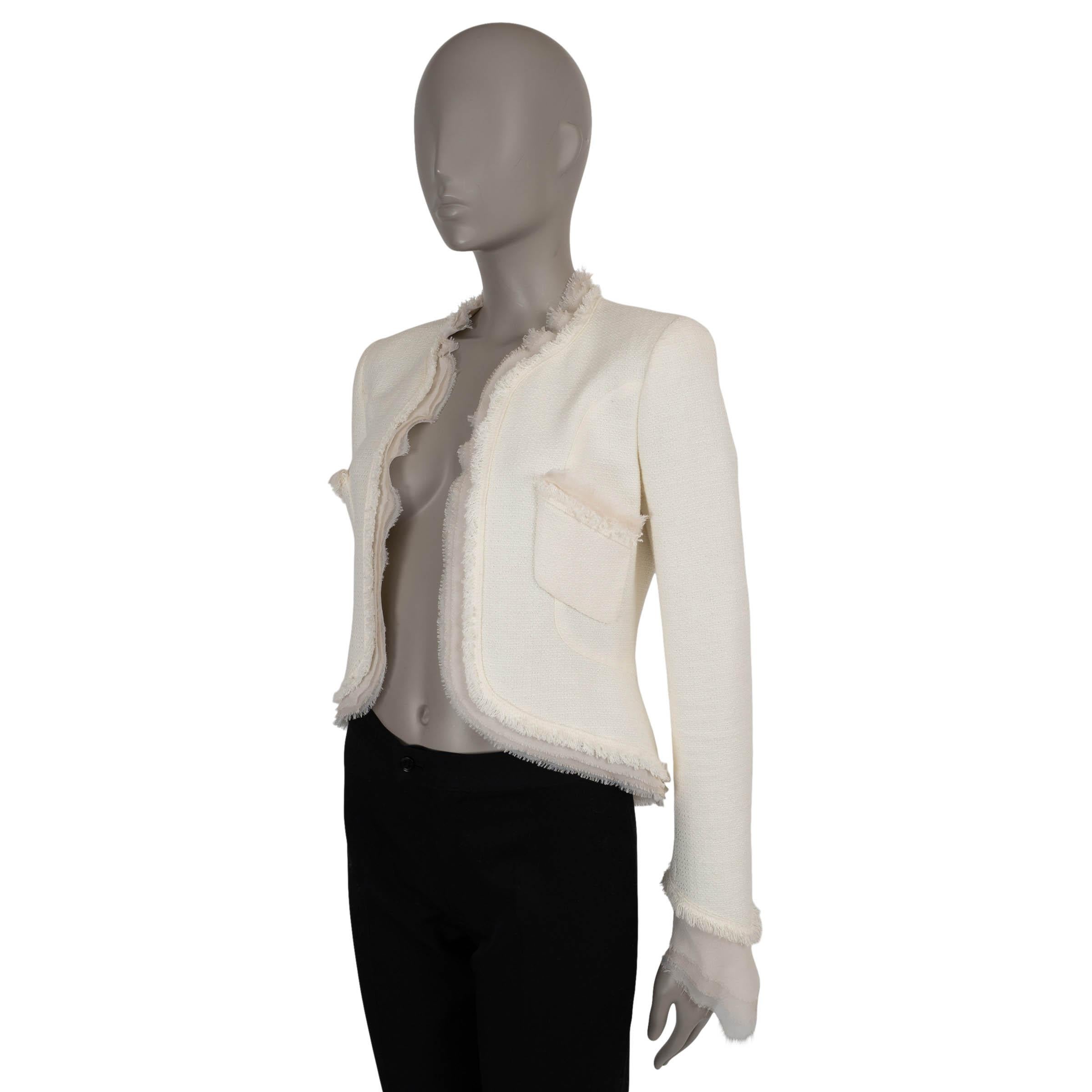 This 100% authentic Chanel jacket in cream tweed cotton (77%) and acrylic (23%) embodies refined elegance with a modern twist. Designed with a fitted, high-low silhouette, it features a collarless neckline adorned with delicate fringe and nude