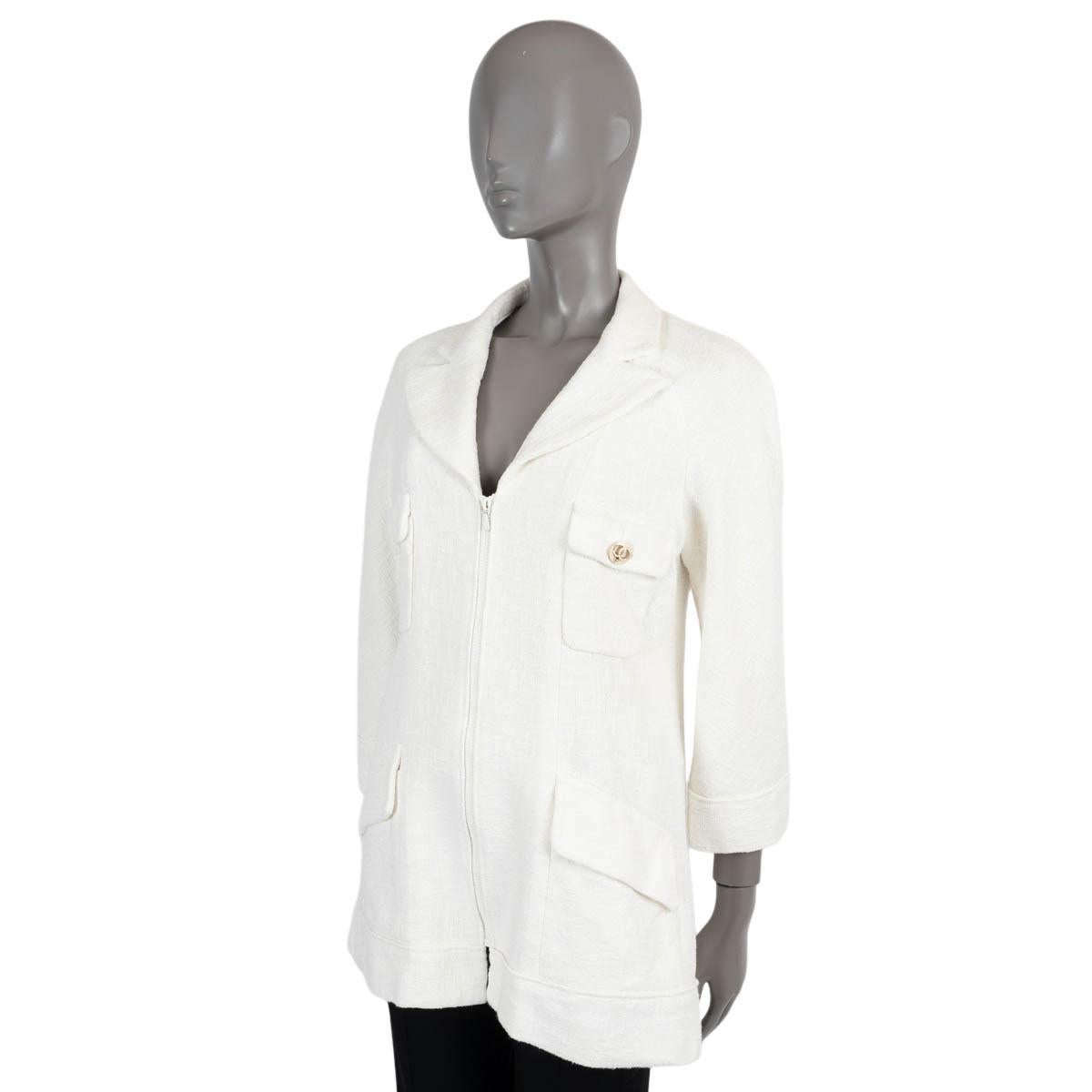 Veste en tweed 100% authentique de Chanel en coton blanc cassé (100%). Il comporte des crêtes, des manches raglan, deux poches boutonnées à rabat sur la poitrine, deux poches à rabat à la taille et deux plis zippés sur les côtés du dos. Il se ferme