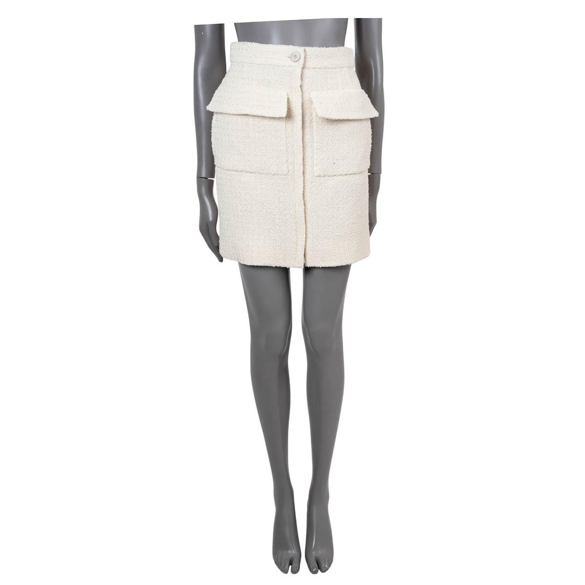 100% authentic Chanel tweed mini skirt in ecru cotton (with 10% polyamide). Features two flap pockets on the front with side slit pockets. Closes with a button and two-way zipper on the front. Lined in handkerchief printed cotton (with 7% silk).