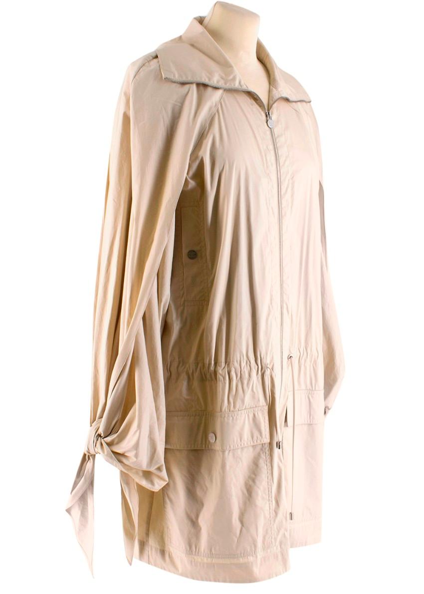 Chanel Cream Drawstring Trench Coat. RRP £3095.00

- Lightweight
- Silver-tone Chanel fastenings
- Mid length 
- Zip up to high-neck collar 
- Tied sleeve detail 
- Open arm slits 
- 4 pockets
- Drawstring waist band

Materials
- 75% Cotton, 19%