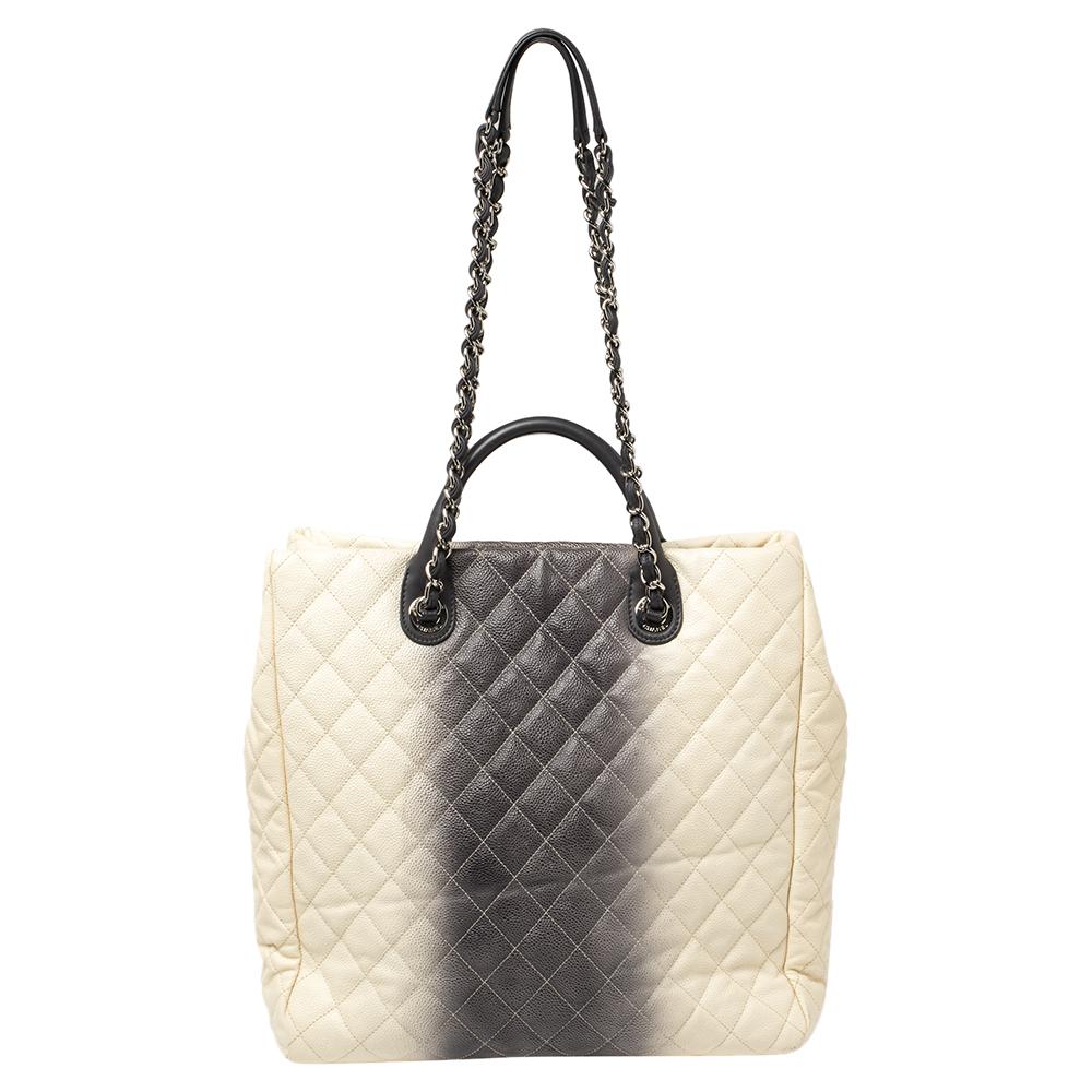 This tote from Chanel is chic and sophisticated! The bag comes crafted from caviar leather and features the signature quilted pattern on the cream & grey ombre exterior. It flaunts the iconic CC in silver-tone on the front and comes equipped with