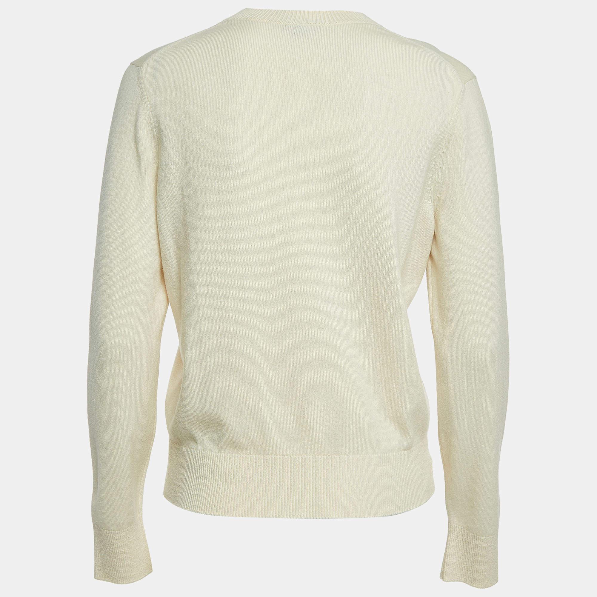 Wrap yourself in warmth and style with this Chanel cream sweater. Meticulously crafted for comfort and fashion, it epitomizes timeless sophistication. Each stitch reflects quality, making it an essential piece for every wardrobe.

