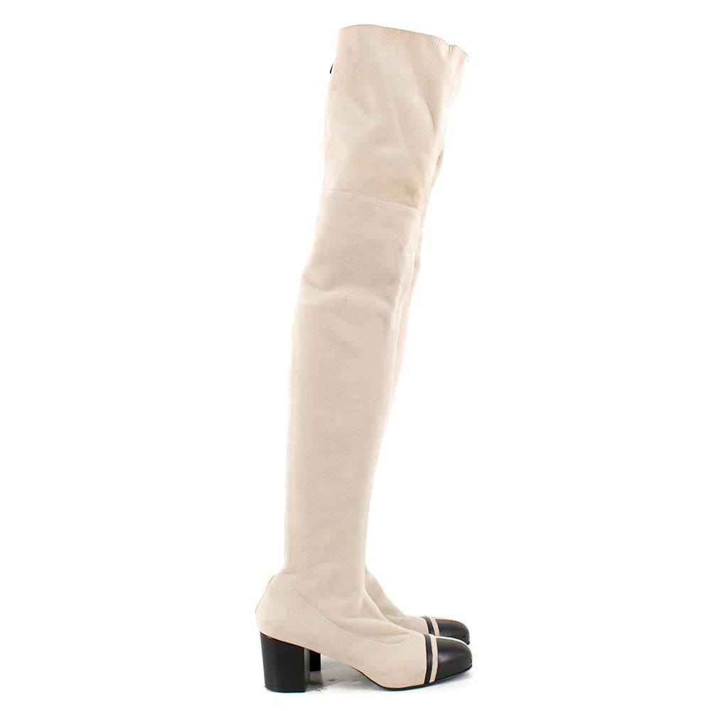 Chanel  Suede Lambskin Stretch Cap Toe Over The Knee Boots

- Smooth suede lambskin leather in light beige
- Fit over the knee
- Rounded toe with a black cap toe
- Back zip fasteining 

Made in Italy 

Please note, these items are pre-owned and may