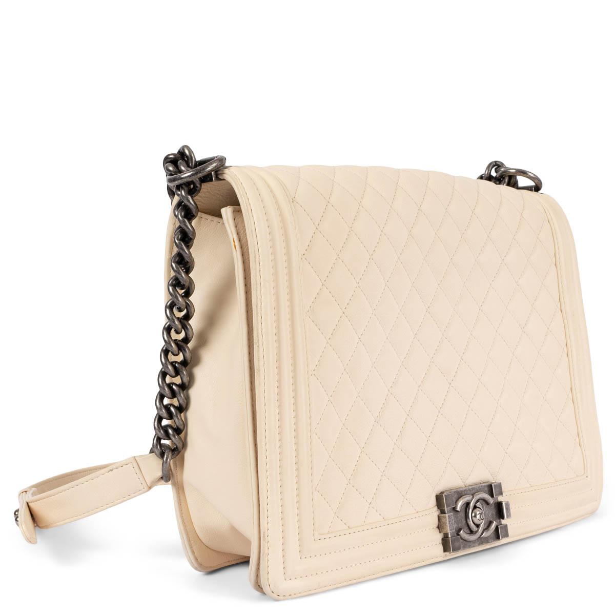 100% authentic Chanel (old) Large Boy flap bag in cream quilted lambskin leather with Ruthenium (anitque silver) hardware. Features a leather and chain strap. Closes with a Boy metal lock on the front. Lined in black grosgrain fabric with two open