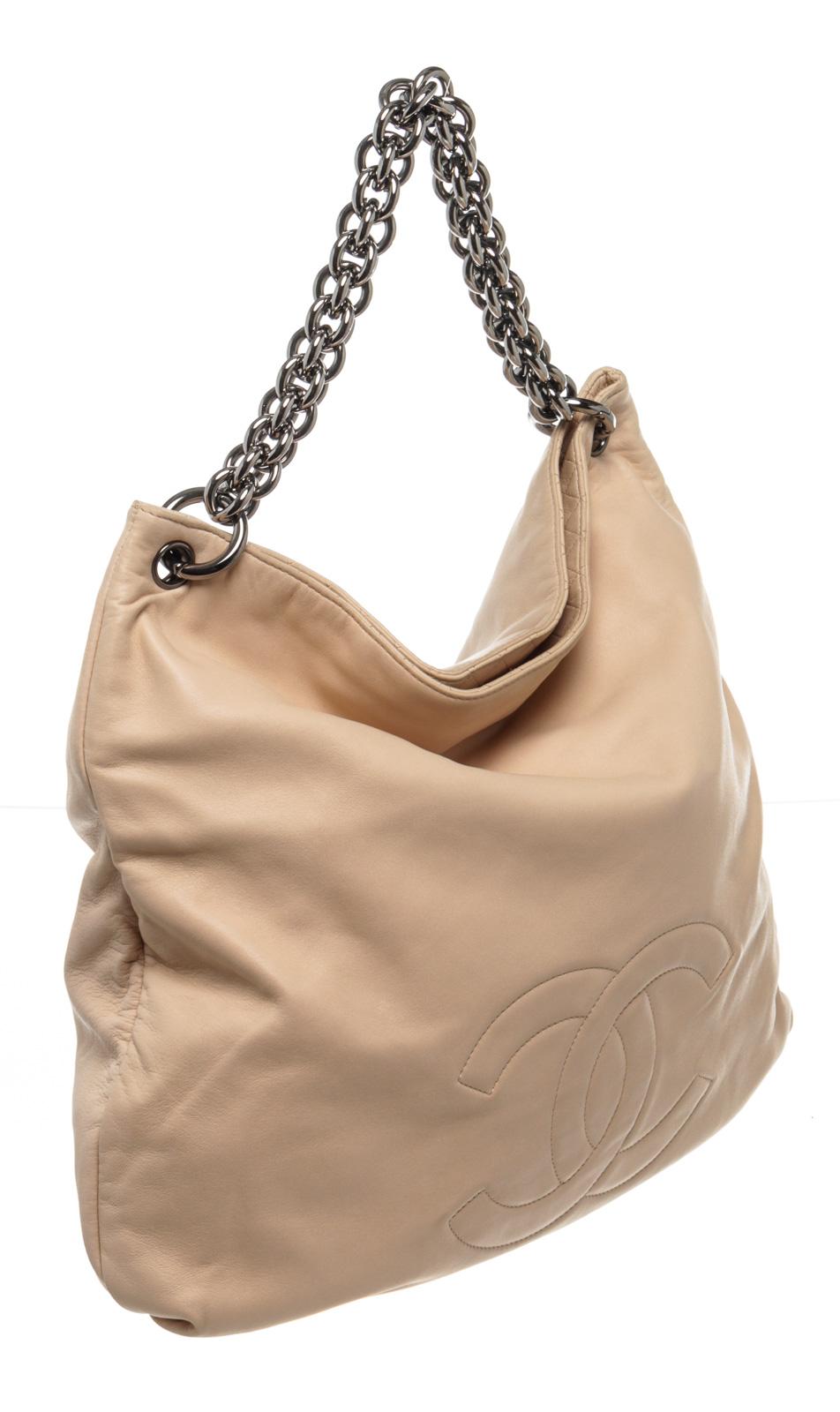 Chanel Cream Leather CC Chain Hobo Bag with leather, gold-tone hardware, interior slip pockets, chain shoulder strap and flap closure.

220053MSC 