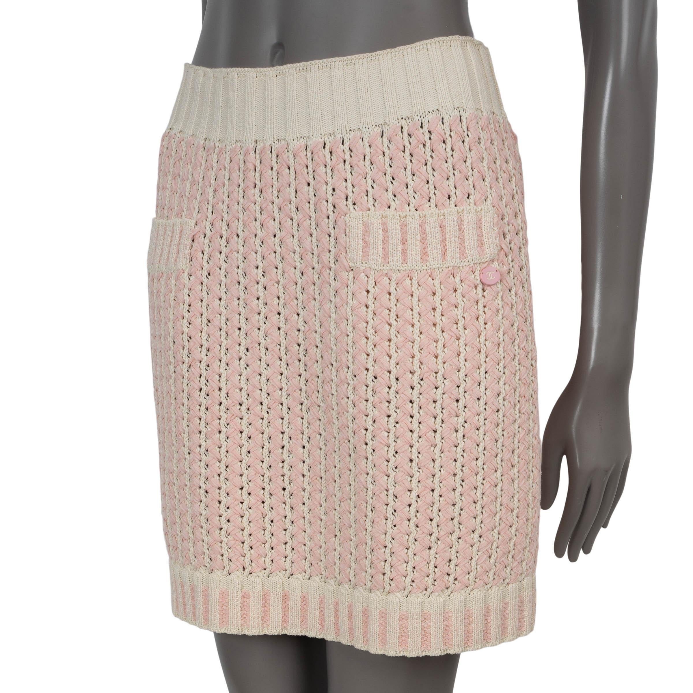 Mini jupe en maille 100% authentique Chanel en coton (95%) et polyamide (5%) ivoire. Il est orné de rubans rose pâle sur l'ensemble du corps, d'un tricot côtelé à la taille et à l'ourlet du bas et de deux poches zippées à la taille. Non doublé. A