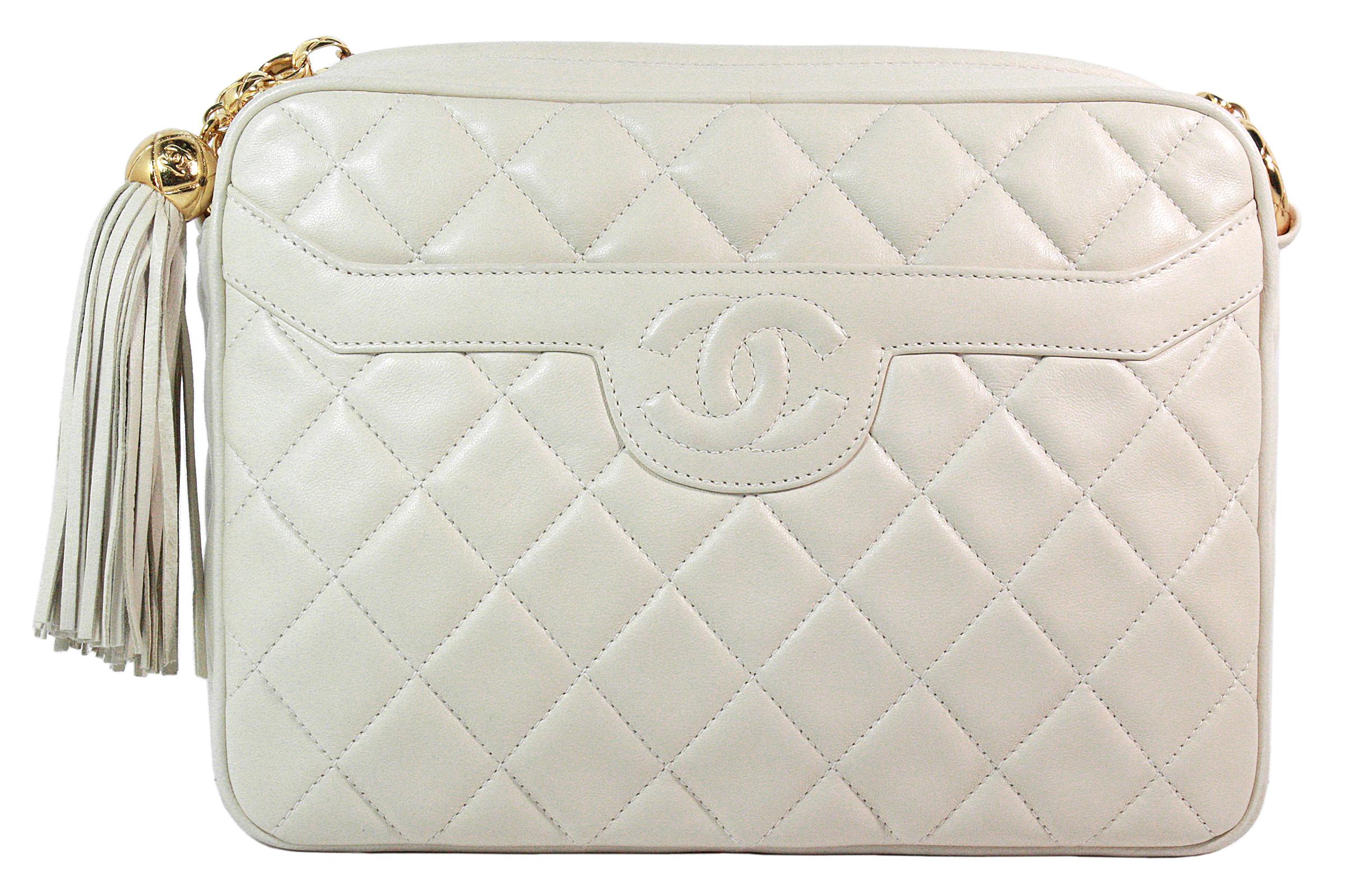 Chanel crossbody bag
Made in Italy
Soft cream quilted leather 
Stitched classic CC logo 
Front pocket 
Gold chain strap
Strap length: 44 inches 
Hanging gold ball and leather fringe detail 
Cream leather lining 
Interior zippered pocket 
Comes with