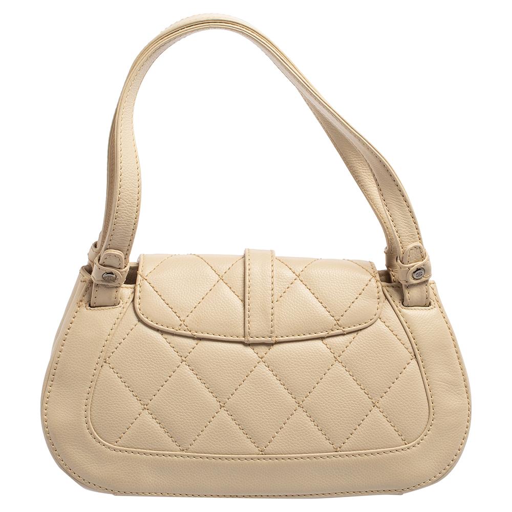 Crafted with precision from fine leather and enveloped in a cream shade, this quilted flap bag from Chanel cannot get any more fabulous than it already is! This piece brings the signature Mademoiselle lock on the front flap and it leads to a