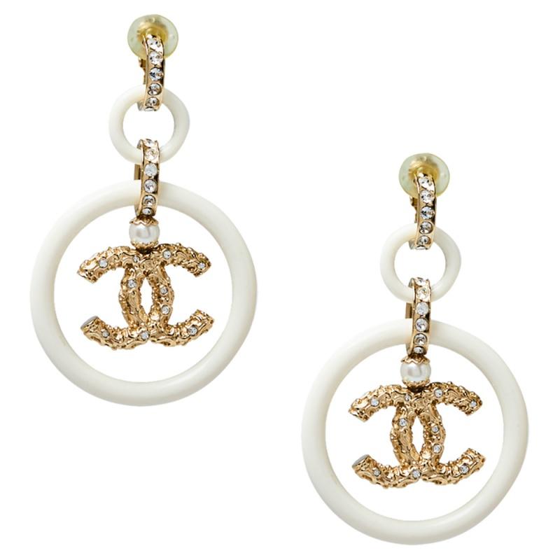 Exhibiting Chanel's rich craftsmanship and creativity, these earrings are so elegant, they are meant to be flaunted. They feature the CC logo, cream resin rings, and crystals. The clip-on back secures the beautiful earrings.

Includes: Info Booklet,