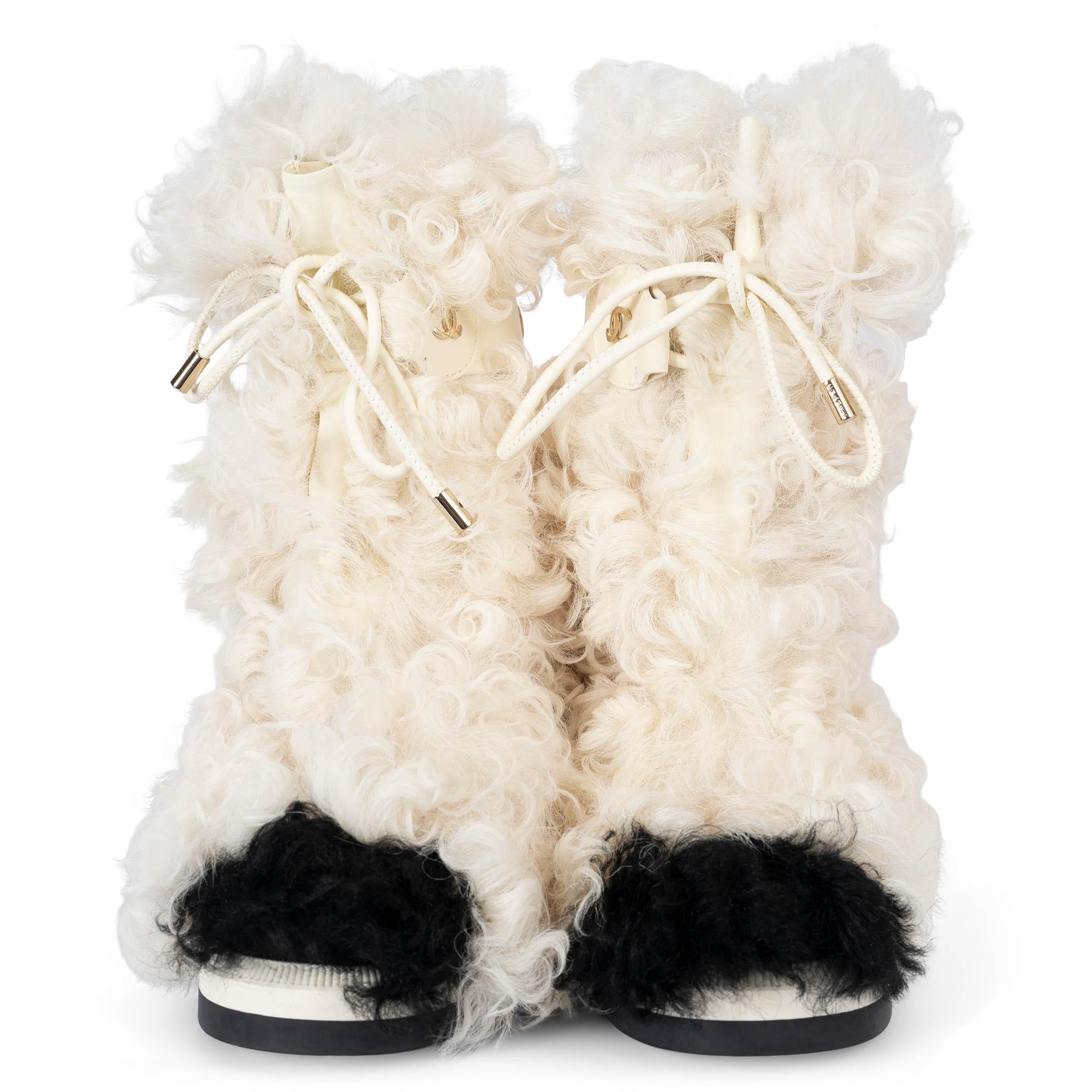 This 100% authentic Chanel Shearling Sheepskin High Boots are crafted from luxurious ivory and black shearling and smooth leather. The design features a white upper with contrasting black toes, creating a classic and stylish look. These stunning