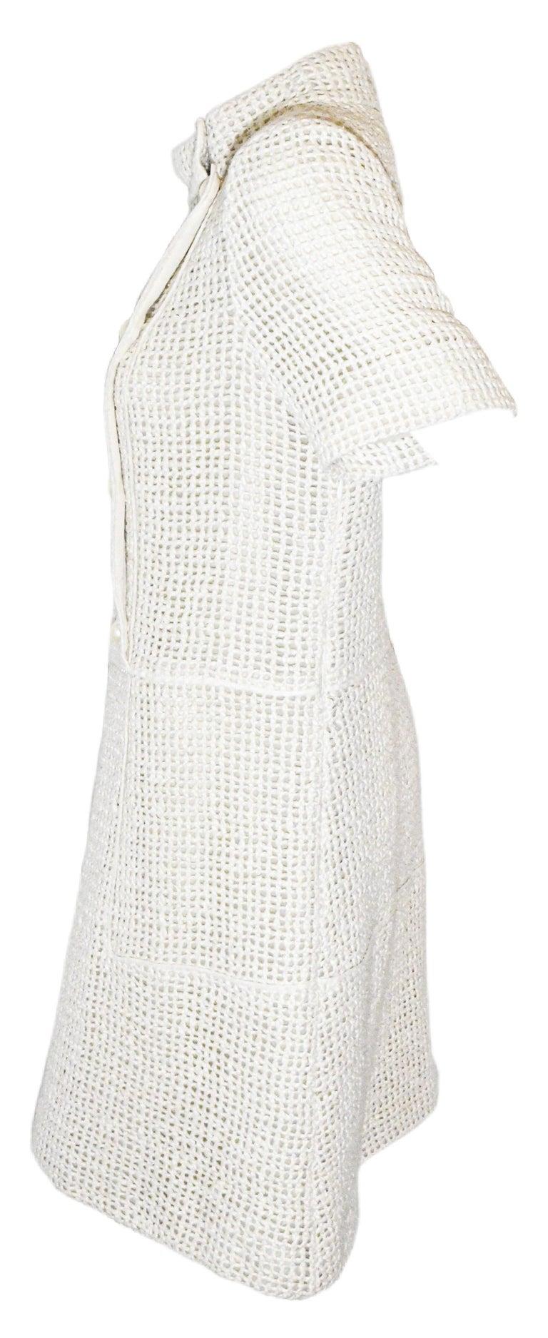 Chanel cream short sleeve Lesage tweed  crochet dress includes 8 faux pearl Chanel embossed buttons at front  and a funnel collar.  This A line dress fits a bit loose to the body contains ivory silk trim at waist and below hip.  For closure a side
