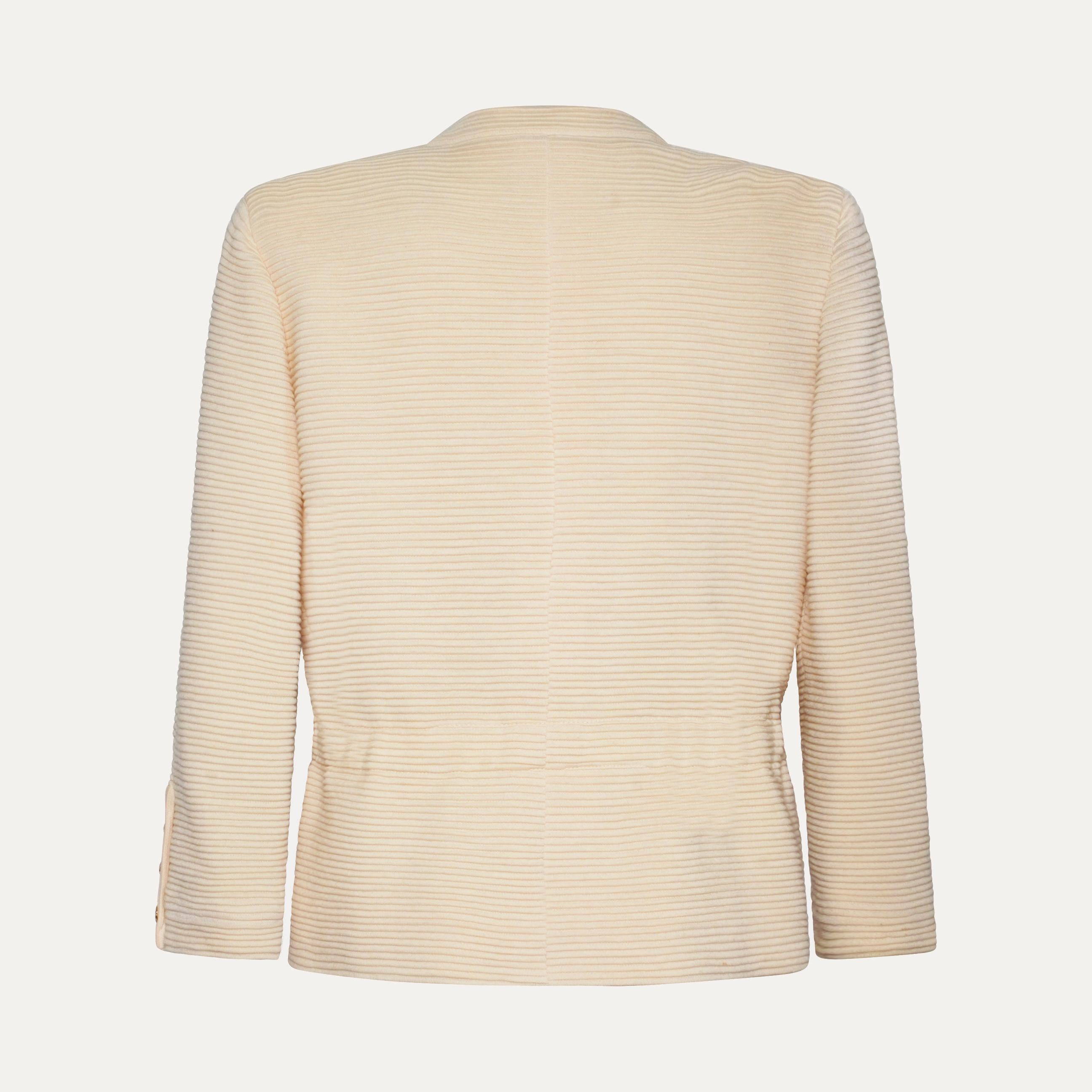 Disegnata da Karl Lagerfeld for Chanel nei primi anni '90, questa giacca in jersey color crema cattura la sobria raffinatezza del decennio di transizione della Maison. Realizzato in Francia, il capo presenta delle nervature orizzontali in rilievo
