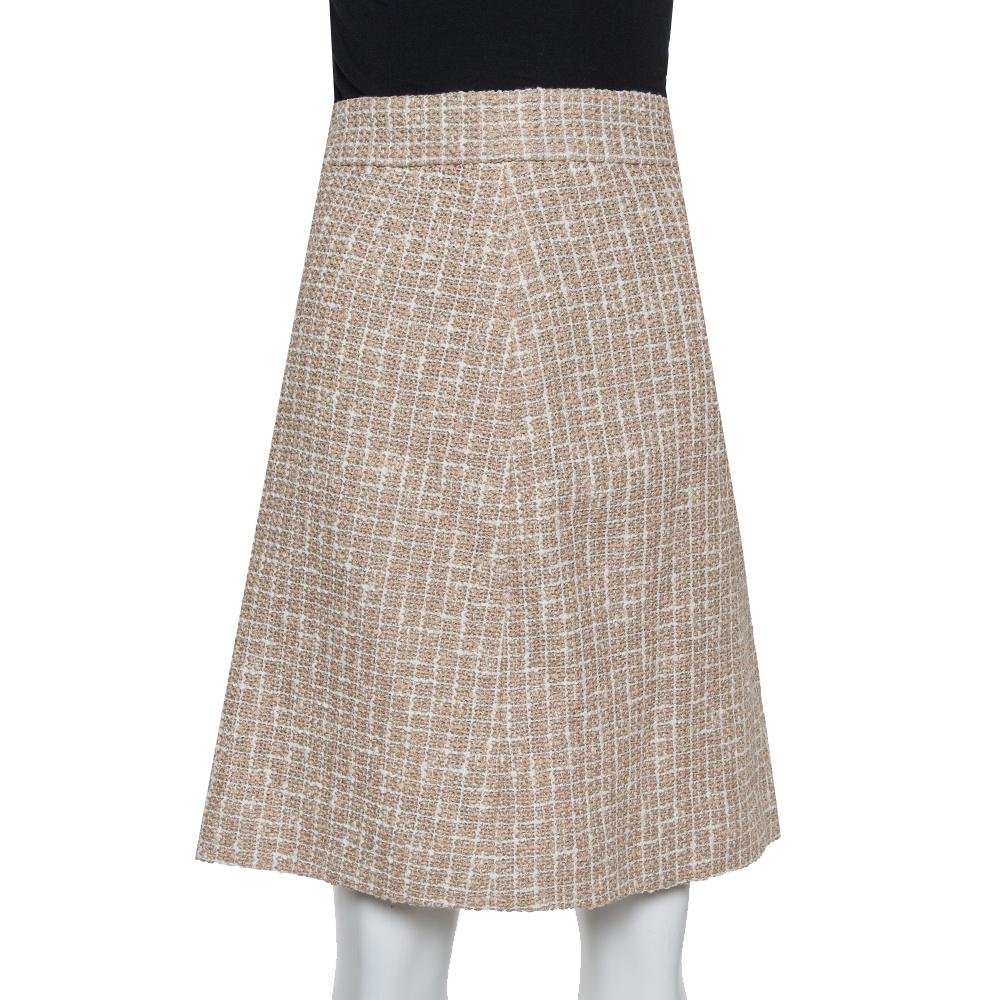 This cream skirt from Chanel will help you outline a sophisticated look. It comes made from tweed into an A-line silhouette. It is lined with silk and is equipped with a zip closure. It will look great with a smart shirt and statement shoes.

