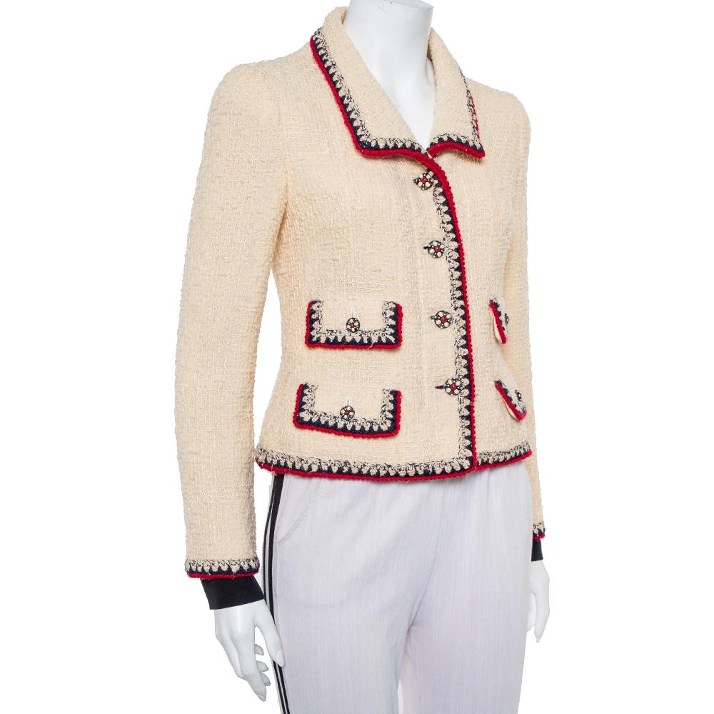 The use of tweed to craft exquisite creations that never go out of style is a signature of Chanel. This classic buttoned jacket is a piece of fashion history that will never disappoint. Crafted from cream tweed, it has a button front and a
