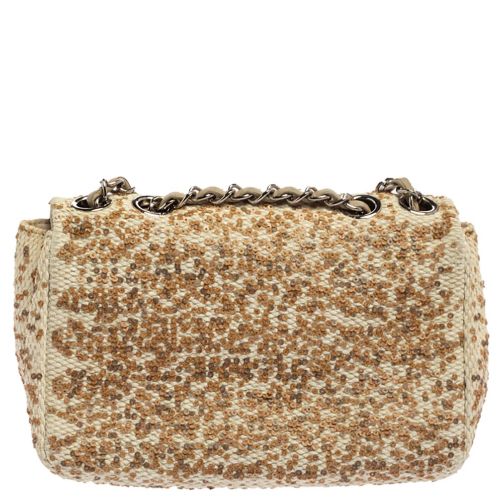 We are in utter awe of this flap bag from Chanel as it is appealing in a surreal way. Exquisitely crafted from raffia and accented with sequins all over, it bears the signature label on the satin interior and the iconic CC turn-lock on the flap. The