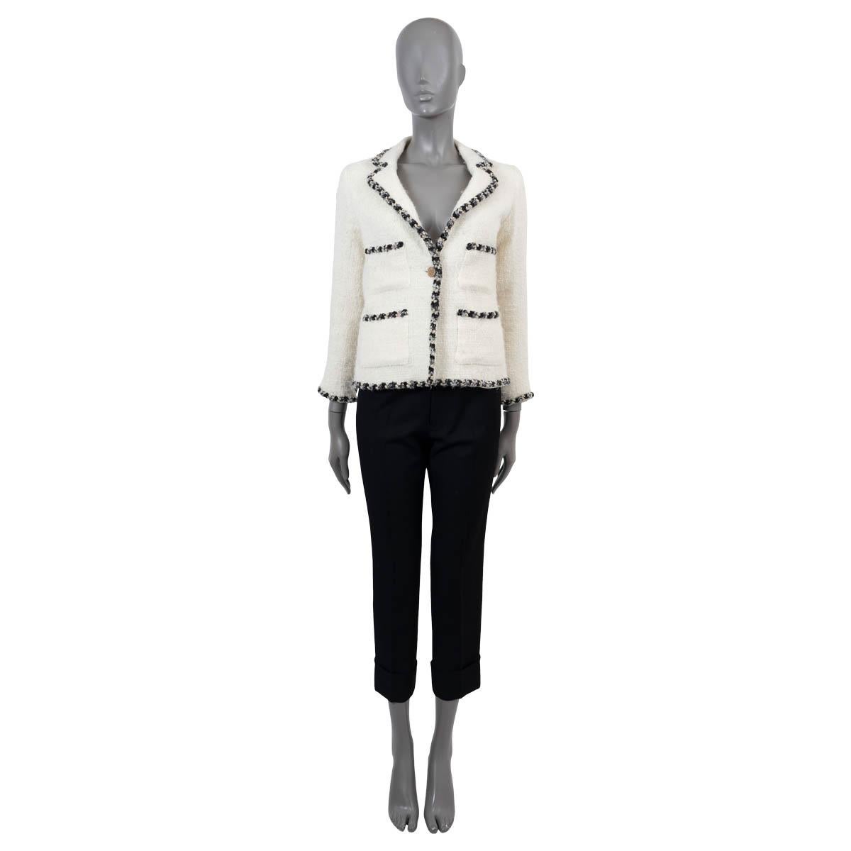 100% authentic Chanel tweed jacket in cream wool (with 3% nylon). Features a contrast braided trim in black, beige and cream, four patch pockets and a notched lapel. Closes with a antique gold button on the front and is lined in silk (with 5%