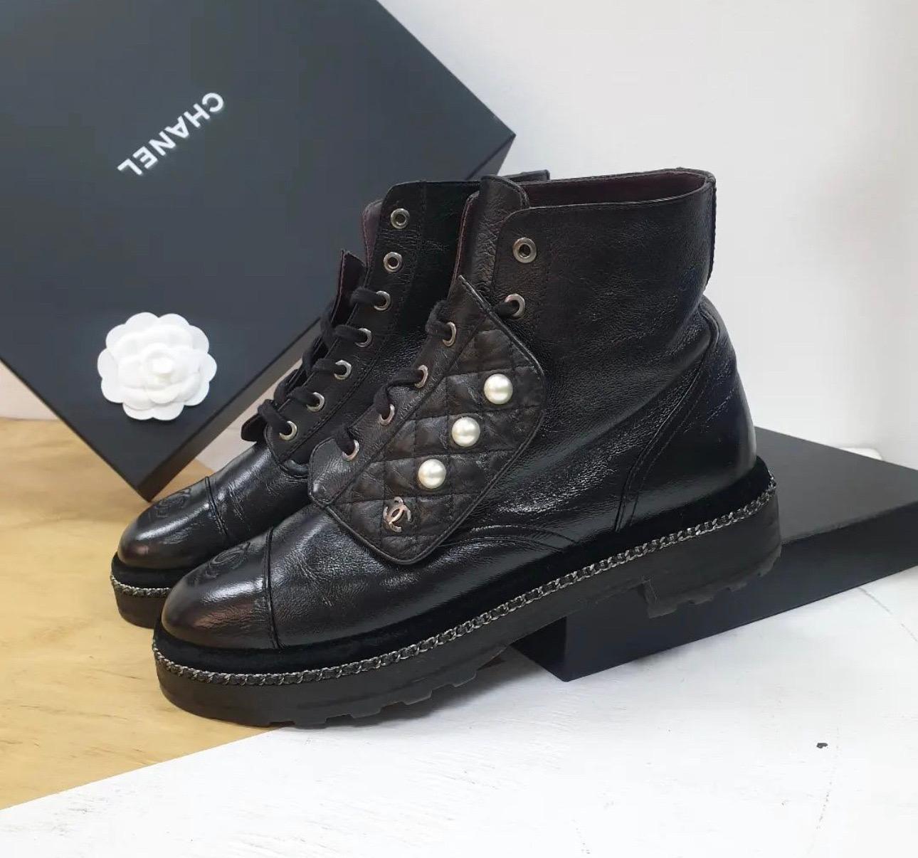 This is an authentic pair of CHANEL Crinkled Calfskin Pearl Combat Short Boots 
Size 39.5 in Black.
These stylish lace up boots are crafted of crumpled black calfskin leather in black. 
They feature rounded black, smooth leather cap toes and a faux