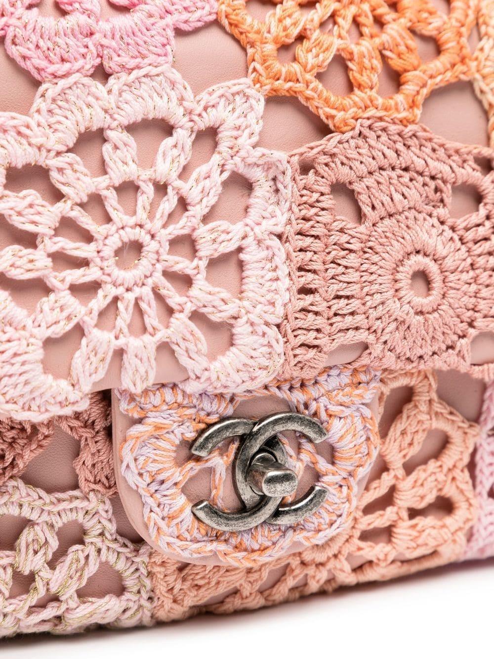 From 16C, this Chanel flap bag is a show-stopper. Made with soft pink leather and an intricate crochet flower outside trim, this is a light-hearted twist on the classic flap. Chanel cruise collections contain some of the most collectable Chanel