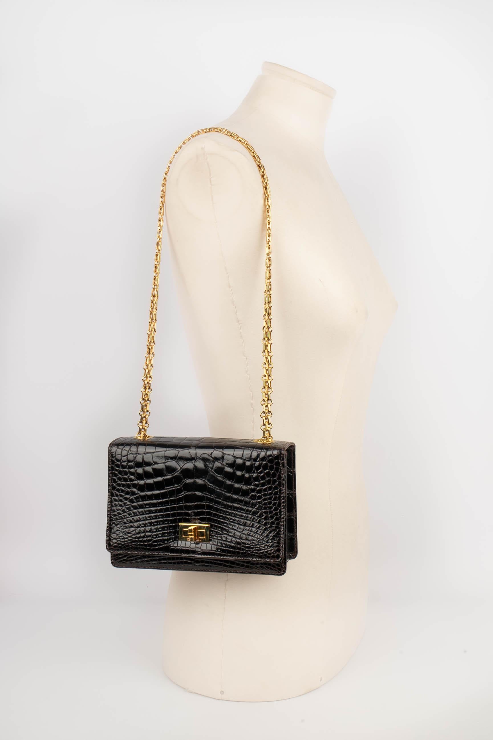 CHANEL - (Made in France) Coffee-coloured crocodile Trapezoid bag with a golden metal Mademoiselle fastener on a flap. Cambon chain handle. Pre-hologram era - 1982 circa collection.

Condition:
Good condition

Dimensions:
Height: 12 cm - Width: 17