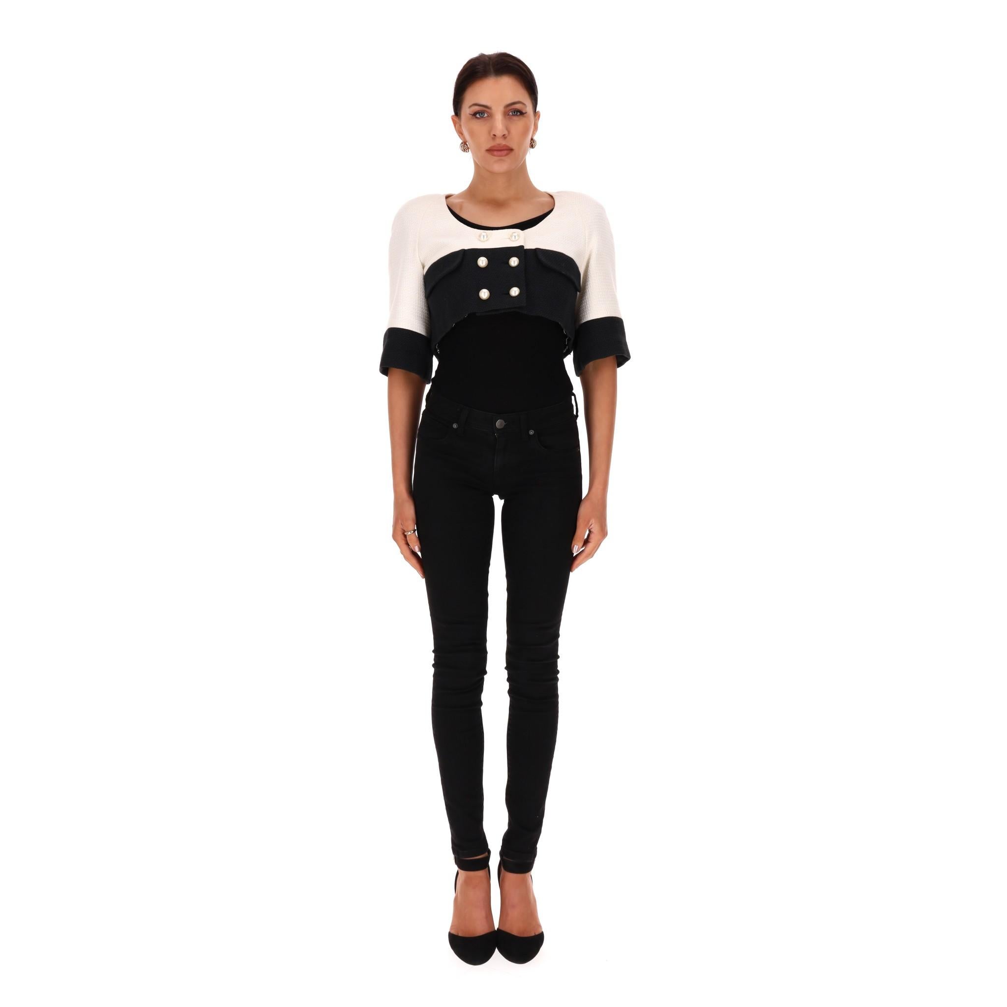 Chanel Cropped Cotton Jacket With Pearl Buttons

White and black textured cropped jacket with double-breasted design and 'Chanel' pearl buttons.

Detailed with flap pockets to the chest, round neckline and three-quarter sleeves.

Featuring signature