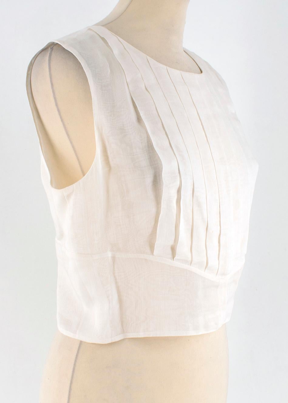 Chanel Cropped White Pleated Silk Top

-Silk Blend, white colour
-Sleeveless 
-Cropped cut
-Pleated front 
-Open-back 
-Hook and fasten closure on back
-Stripped white buttons with signature 
