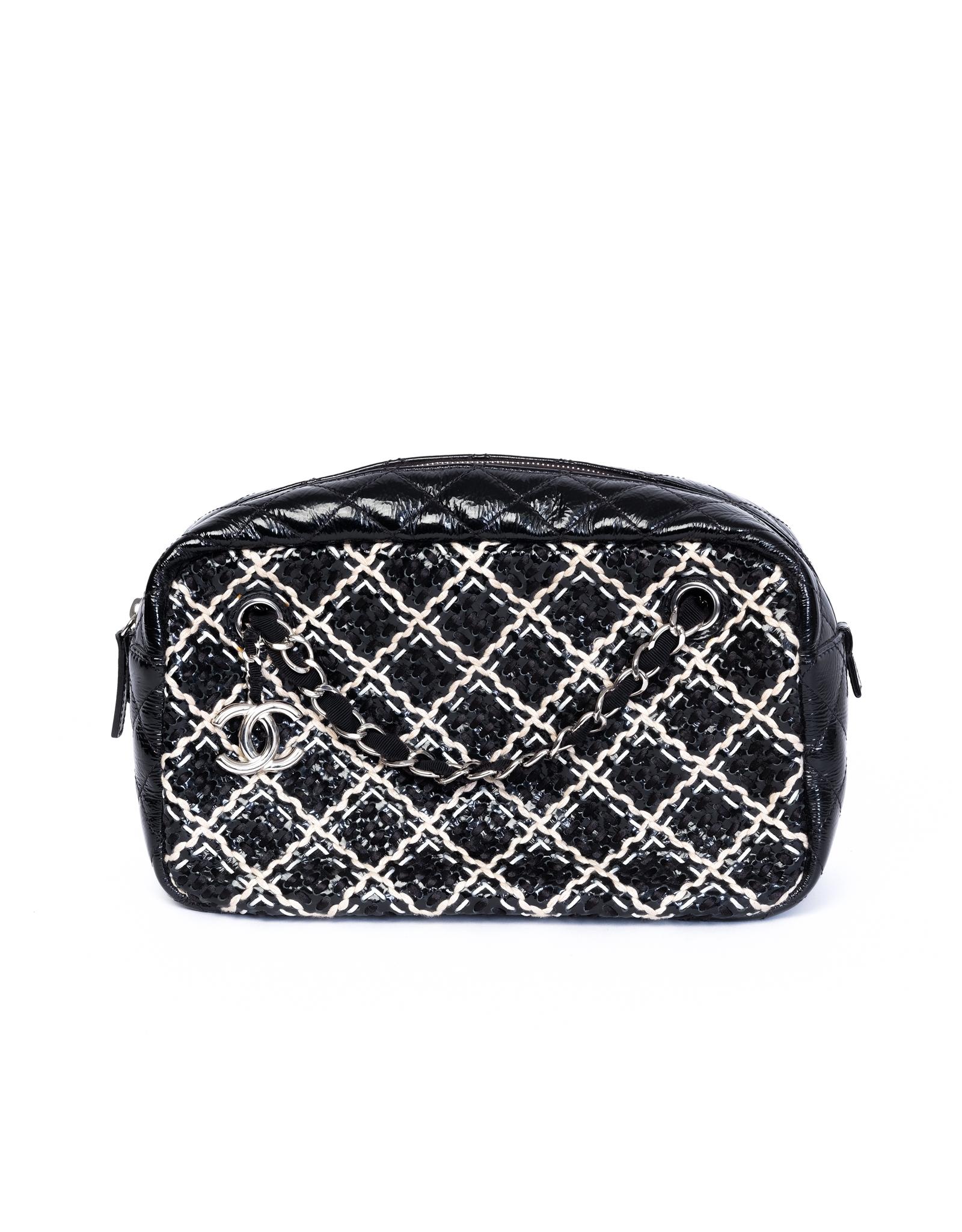 This vintage 2011 Chanel Camera Bag is constructed in woven fabric and patent leather with the signature diamond pattern stitch. Featuring a black and white cross diamond woven exterior, silver toned hardware with an interlocking CC logo pendant,