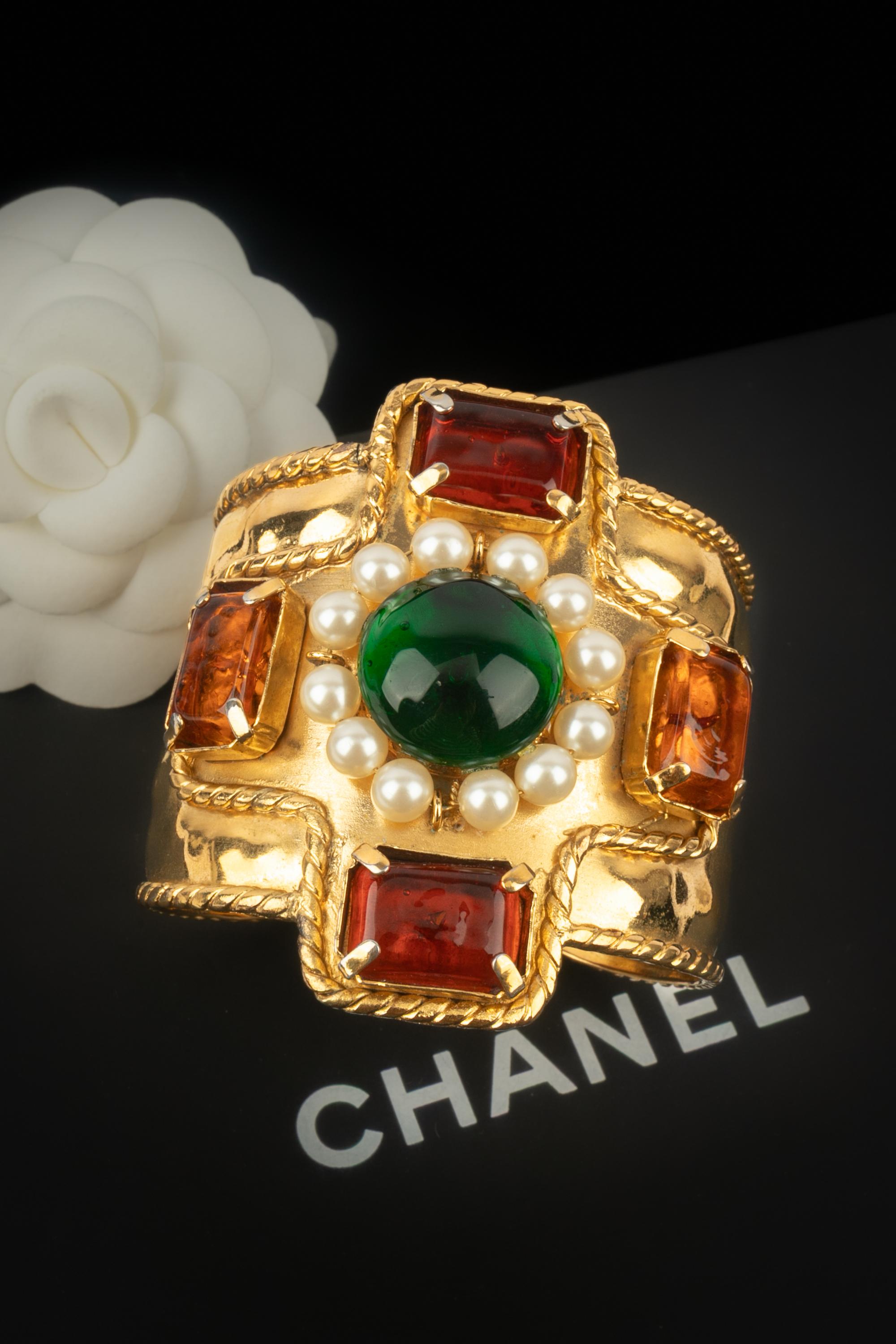 CHANEL - (Fabriqué en France) Bracelet manchette en métal doré avec cabochons en pâte de verre et minuscules perles fantaisie. Une Collection S sous la direction artistique de Karl Lagerfeld.

Condit :
Très bon état.

Dimensions :
Circonférence : 15