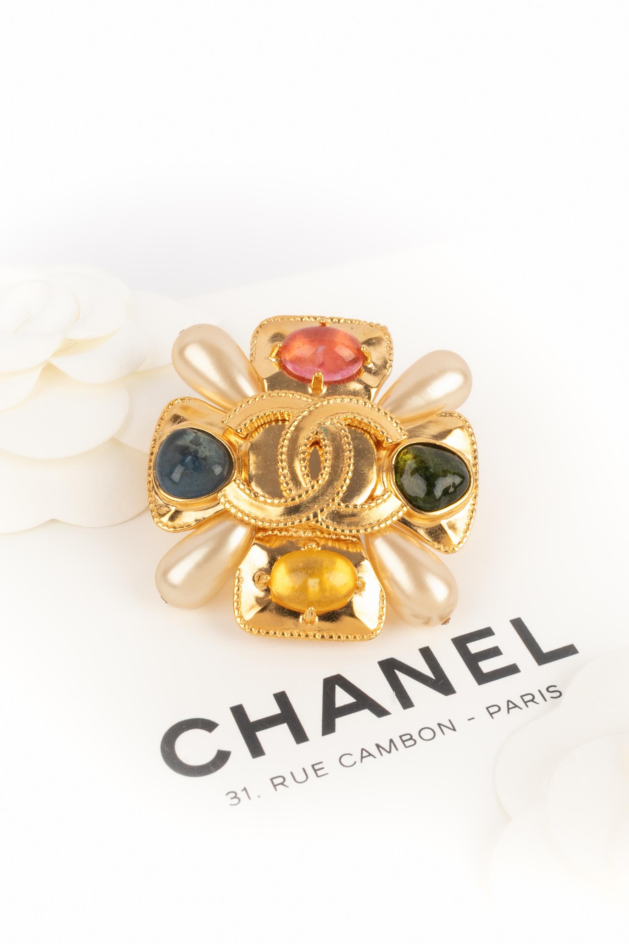 CHANEL - (Made in France) Golden metal cross brooch with glass paste and costume pearly drops. 1997 Fall-Winter Collection under the artistic direction of Karl Lagerfeld.

Condition:
Very good condition

Dimensions:
5.5 cm x 5.5 cm

SKU:BRB140