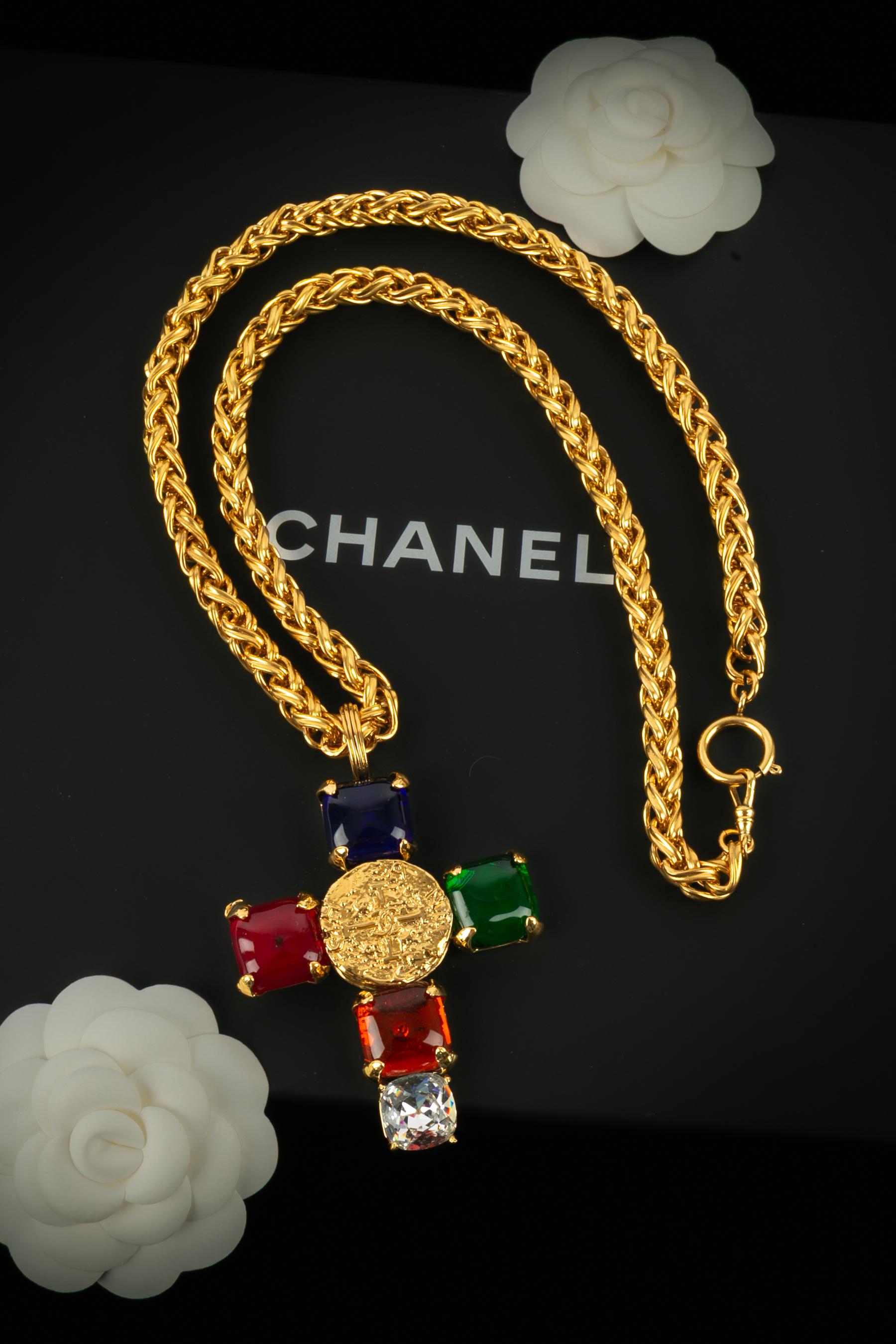 Chanel - (Made in France) Lunga collana a catena in metallo dorato con un ciondolo a croce ornato da cabochon in pasta di vetro e strass. Collezione Autunno-Inverno 1993 sotto la direzione artistica di Karl Lagerfeld.

Condizioni:
Ottime
