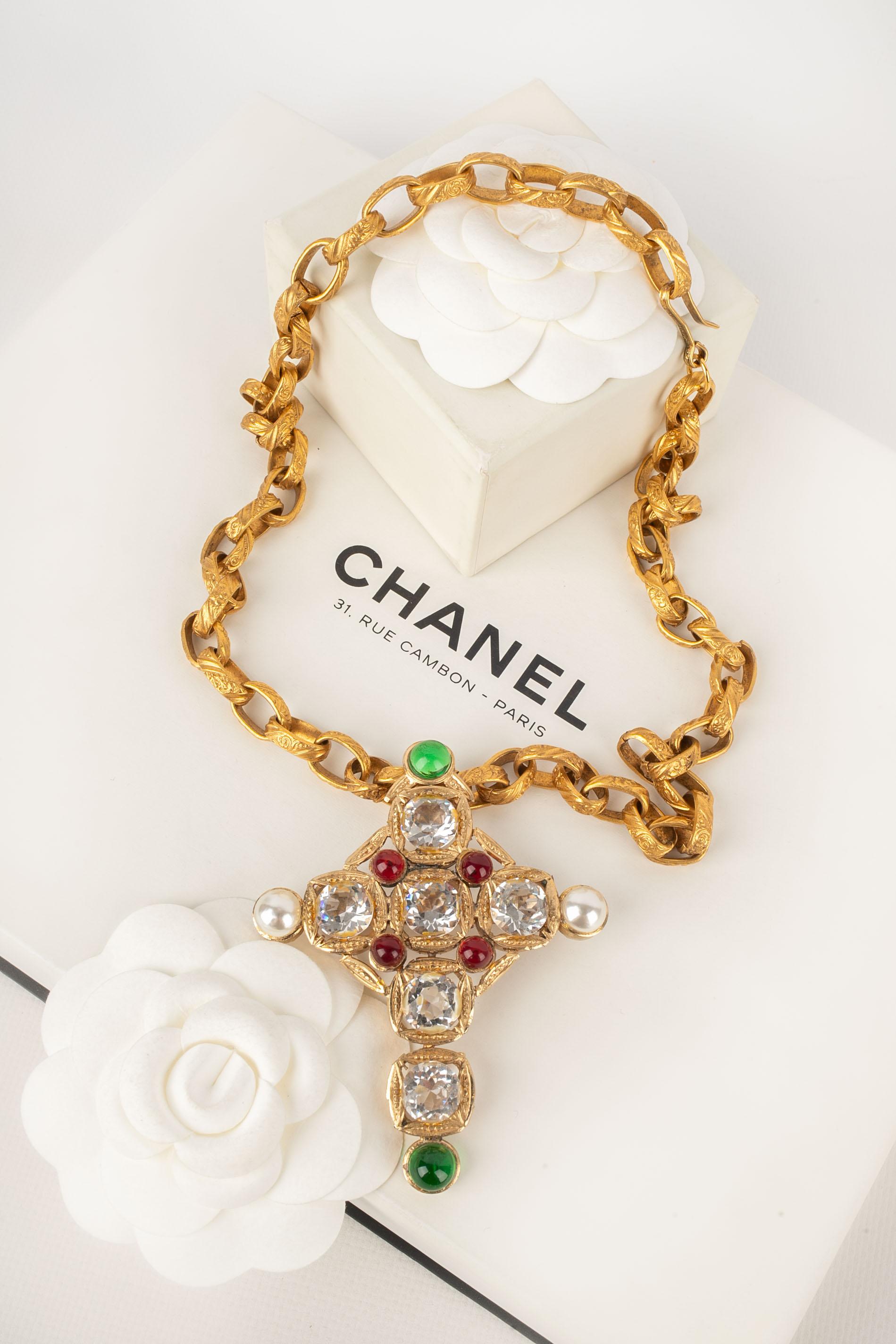 Chanel - Collana in metallo dorato con un ciondolo a forma di croce ornato da strass, perle in costume e cabochon in pasta di vetro. Gioielli non firmati creati dall'Atelier A di Gripoix per la maison Chanel.

Condizioni:
Ottime