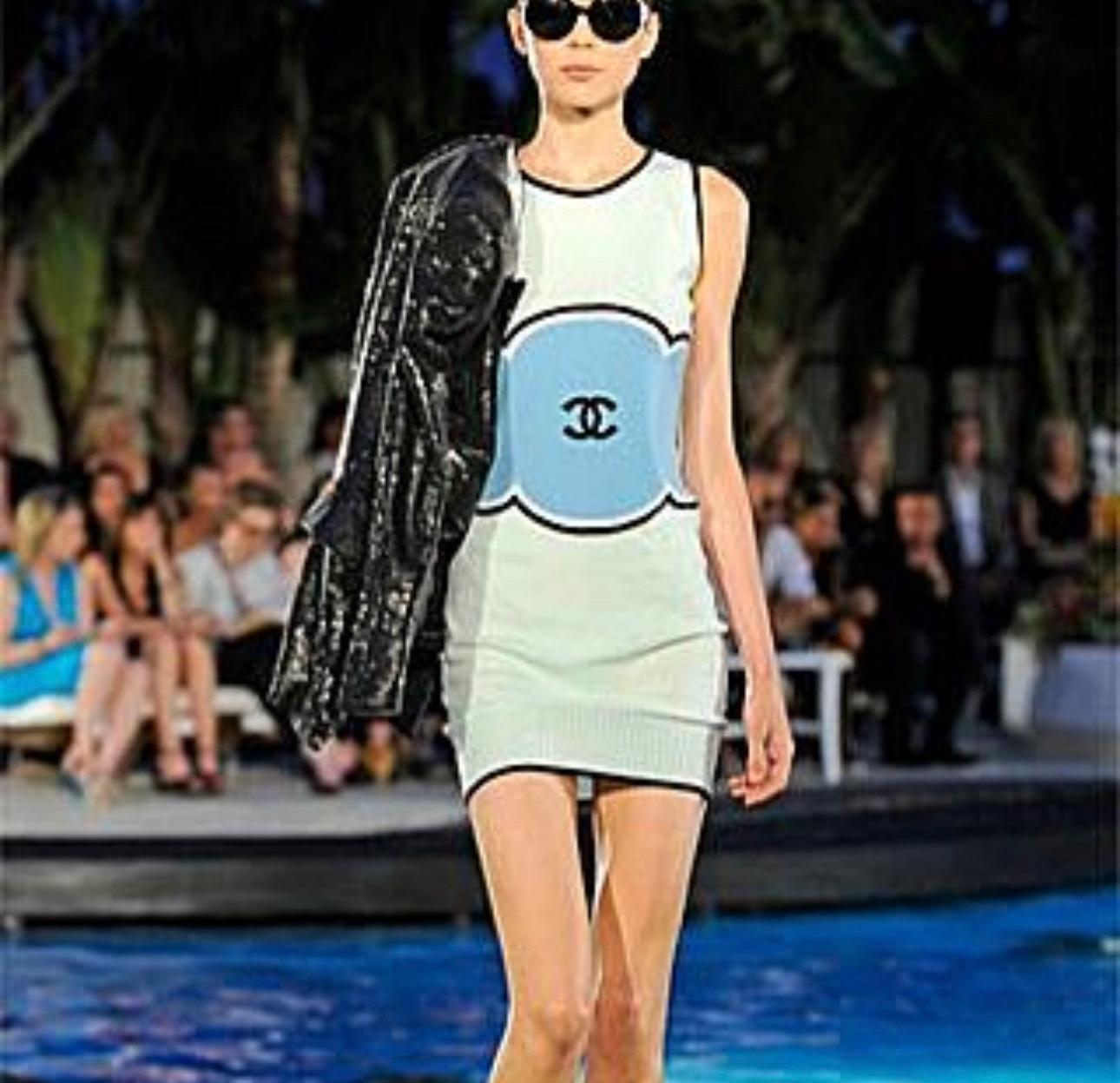 FROM AN EARLY CHANEL CRUISE 2009 COLLECTION, THIS GREEN KNIT DRESS IS MADE OF CASHMERE. INCREDIBLY RARE AND SPECIAL FOR COLLECTORS. FEATURES A BLACK CC LOGO IN THE CENTER, WITH A BLUE BORDER AROUND IT. THE PIECE CAN STRETCH TO FIT VARIOUS SIZES AND