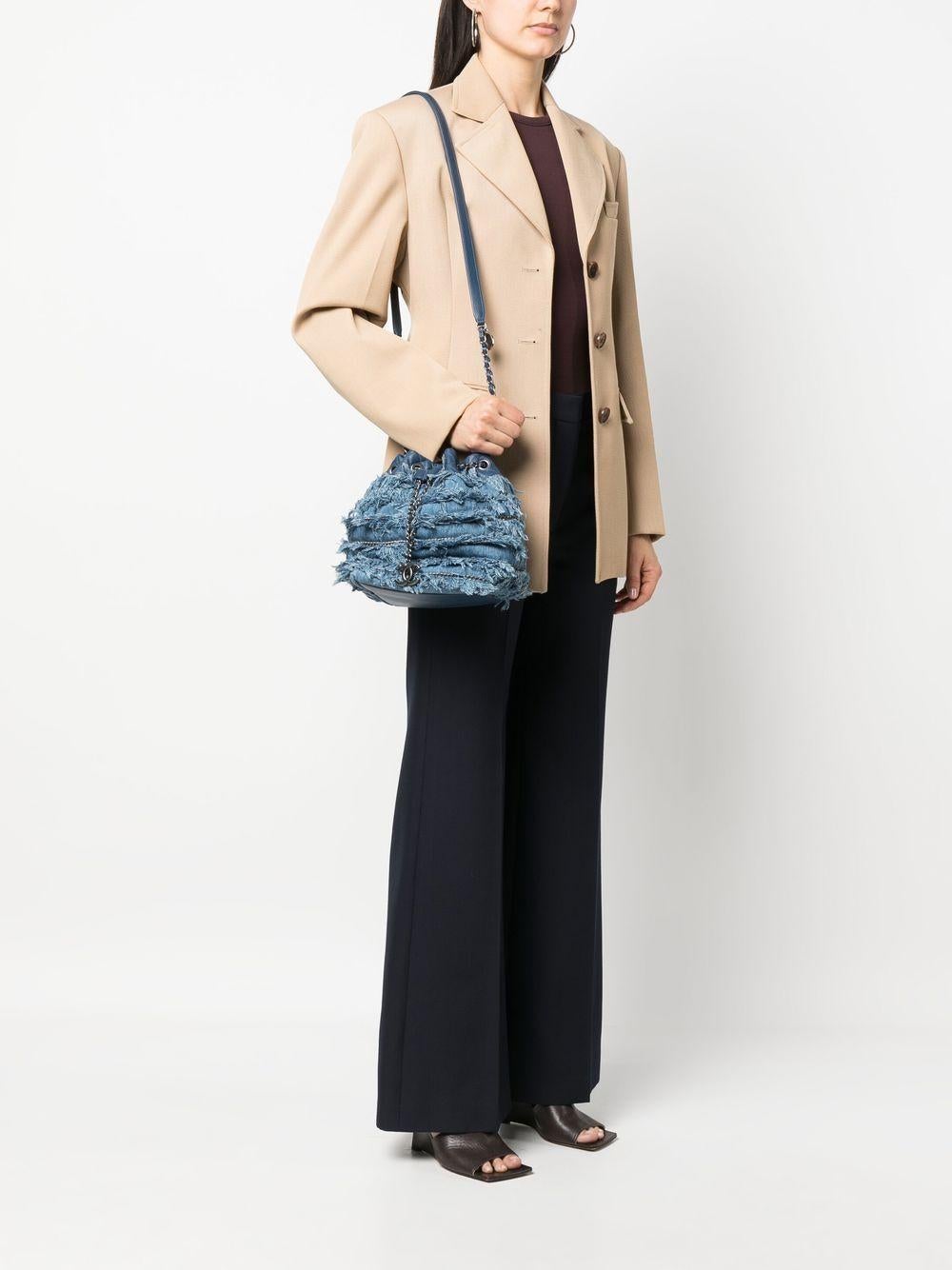 Chanel Rare Cruise 2015 Denim Tweed Fringe Bucket Bag

Antiqued ruthenium hardware
Blue denim Chanel bucket bag
Drawstring CC Logo closure at front
Classic interwoven chain strap
Charm embellishments
Tonal blue canvas lining
Open pocket at interior