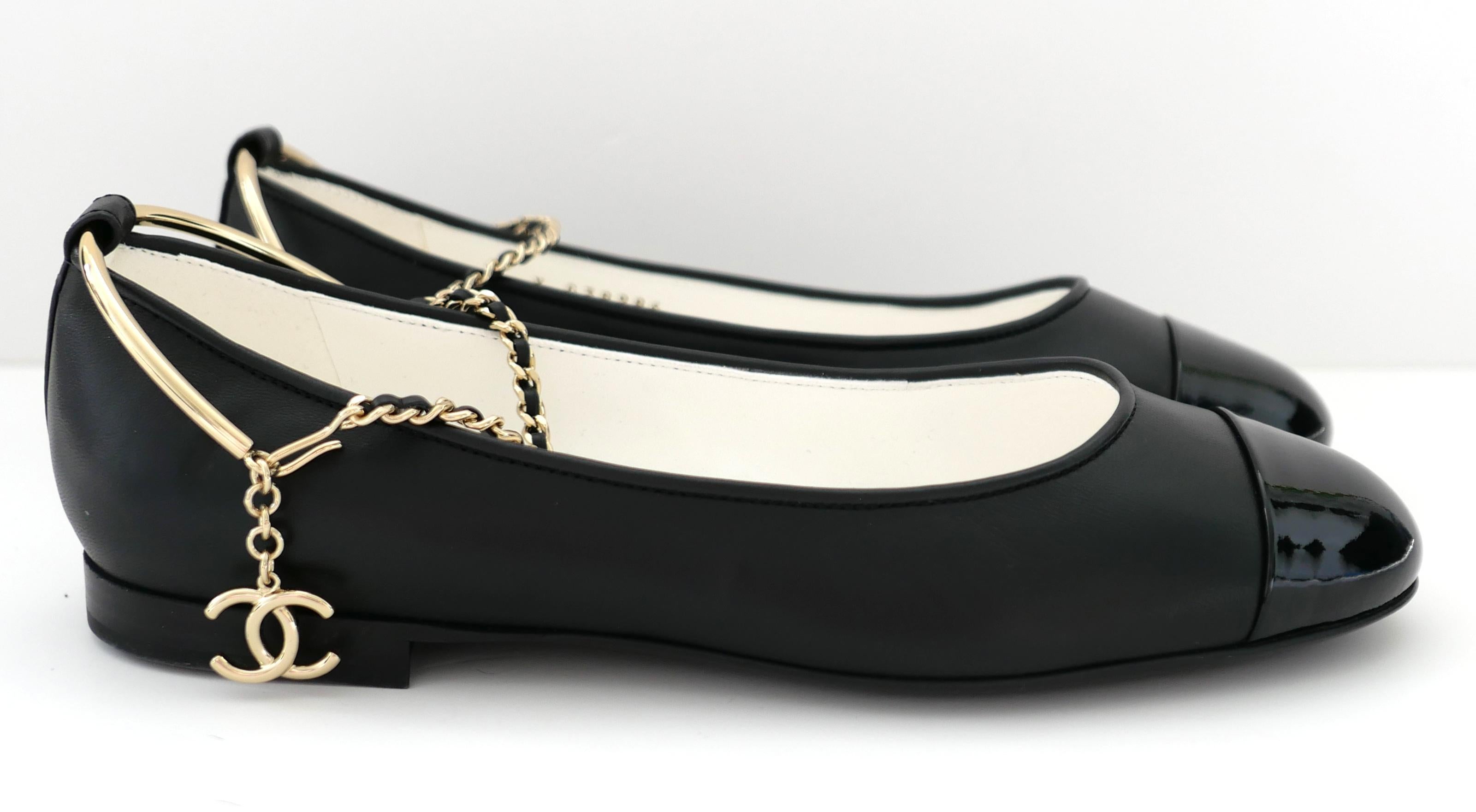 Future collectable Chanel charm ankle ballet flats from the Spring 2022 collection. New with box, leaflet and 2 x dustbags. 
Made from smooth black lamb leather with patent CC stitched toe caps, they have removable goldtone bar and chain ankle
