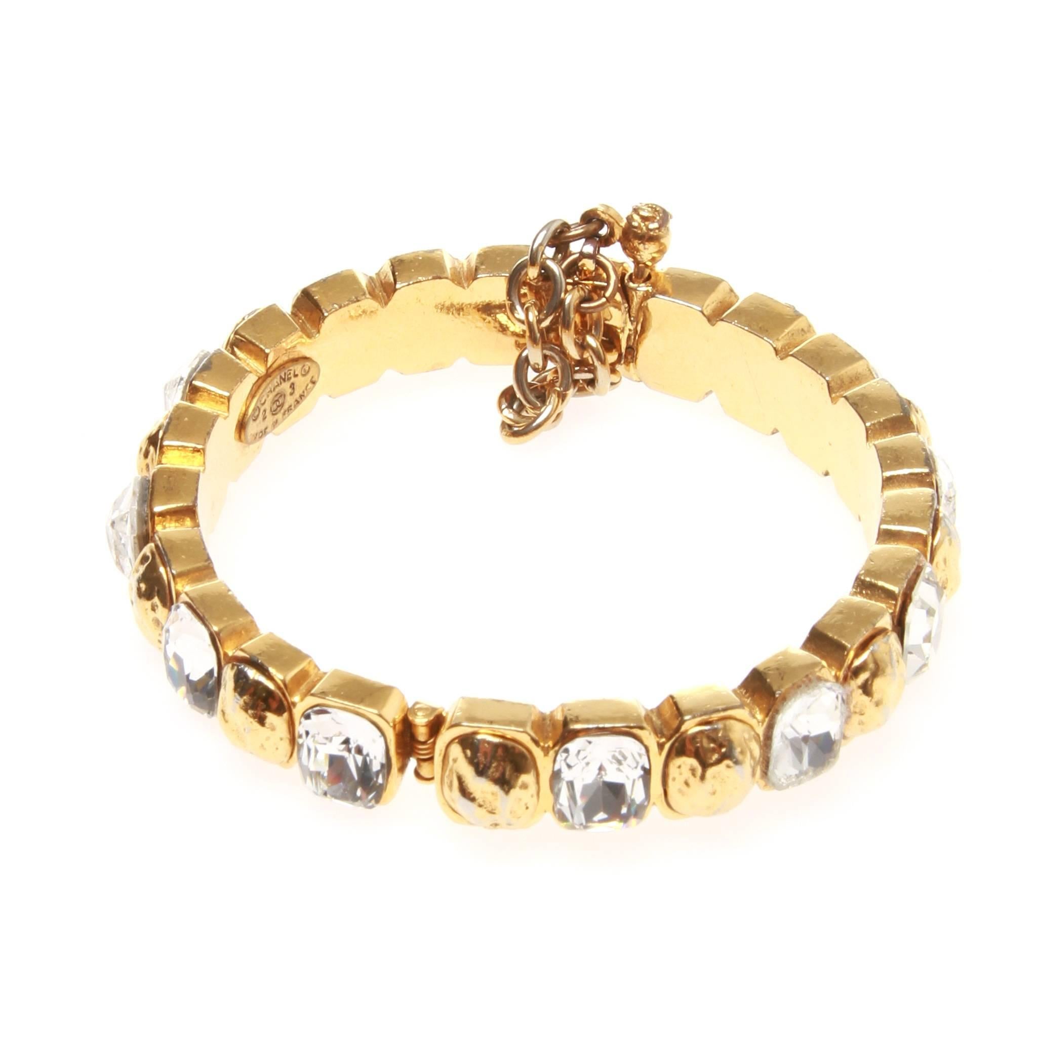 Vintage Chanel bracelet in gold-tone metal featuring a band of alternating gold metal and Swarovski crystal. Hinged mechanism with pin fastening. 

Stamped 2 3 - Collection 23 - c. late 80s
