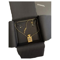 Collana Chanel con cristalli CC e profumo d
oro e catena in pelle nera