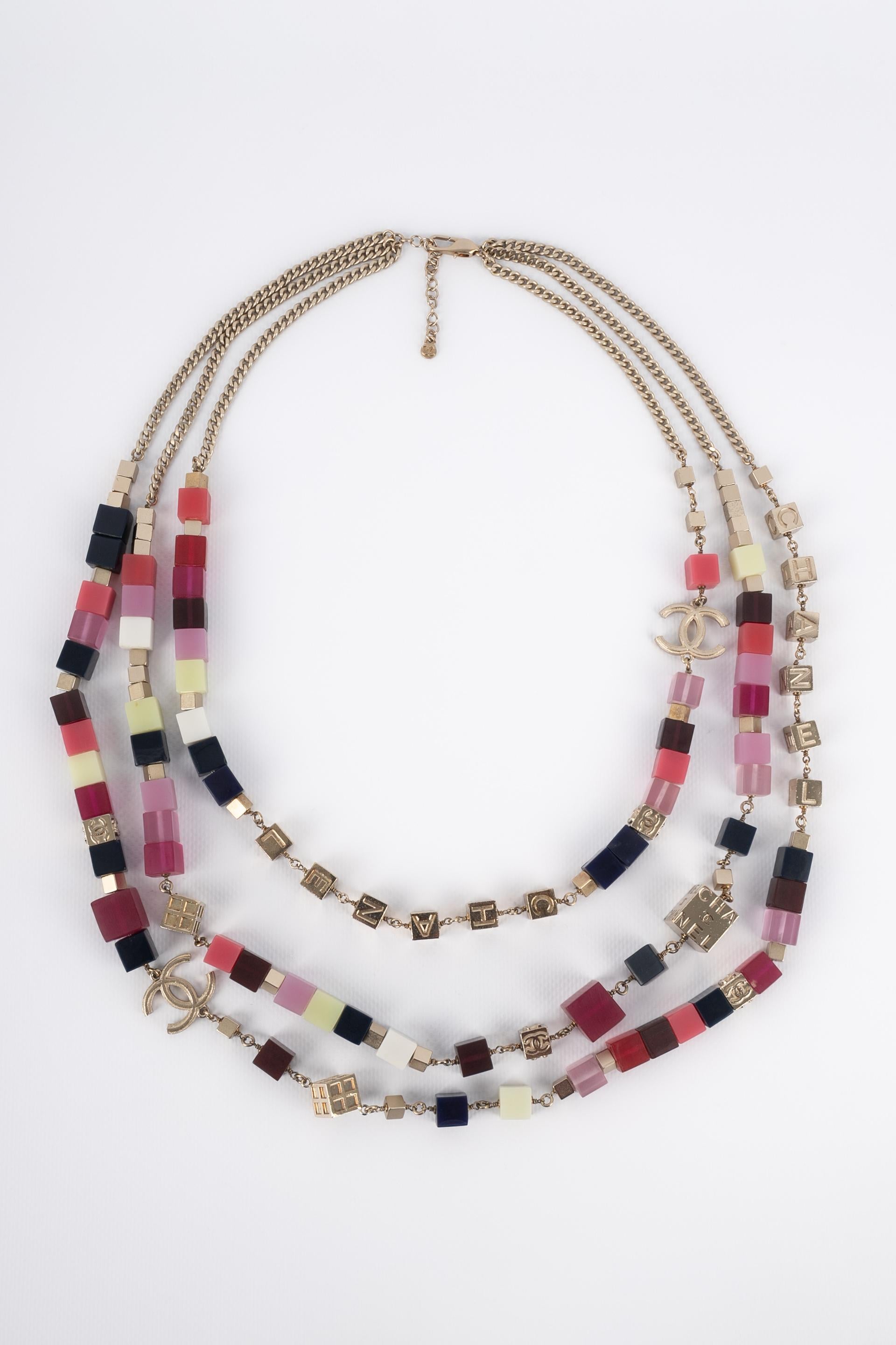 CHANEL - (Made in France) Silvery metal three-row necklace with colored resin cubes. 2004 Spring-Summer Collection under the artistic direction of Karl Lagerfeld.

Condition:
Very good condition

Dimensions:
Length of the shorter row: from 68 cm to