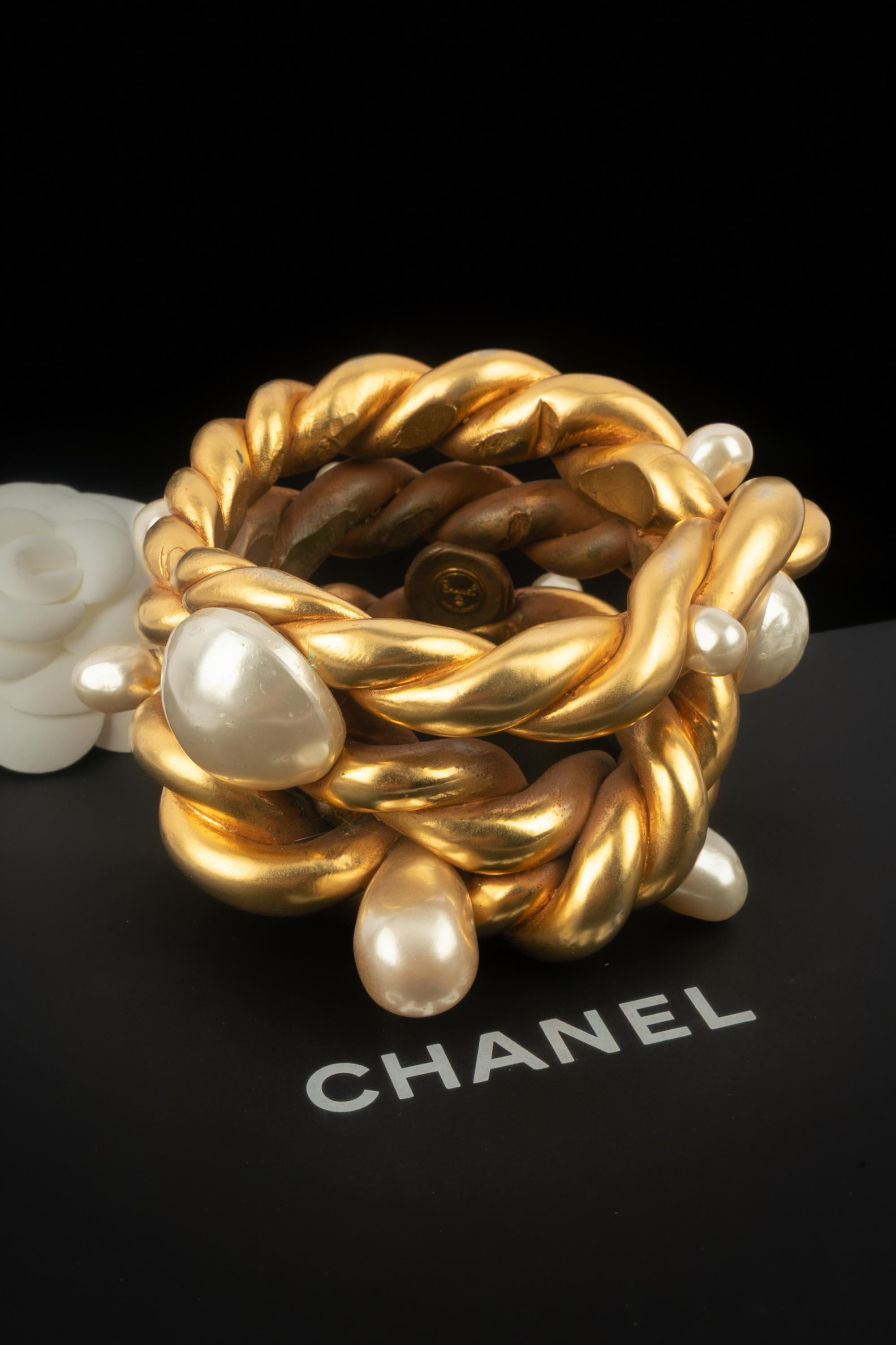 CHANEL - (Fabriqué en France) Bracelet en métal doré orné de perles fantaisie. Collection printemps-été 1990 sous la Direction artistique de Karl Lagerfeld.

Condit :
Très bon état.

Dimensions :
Circonférence : 22 cm - Largeur : 5,5 cm

SKU:BRAB137