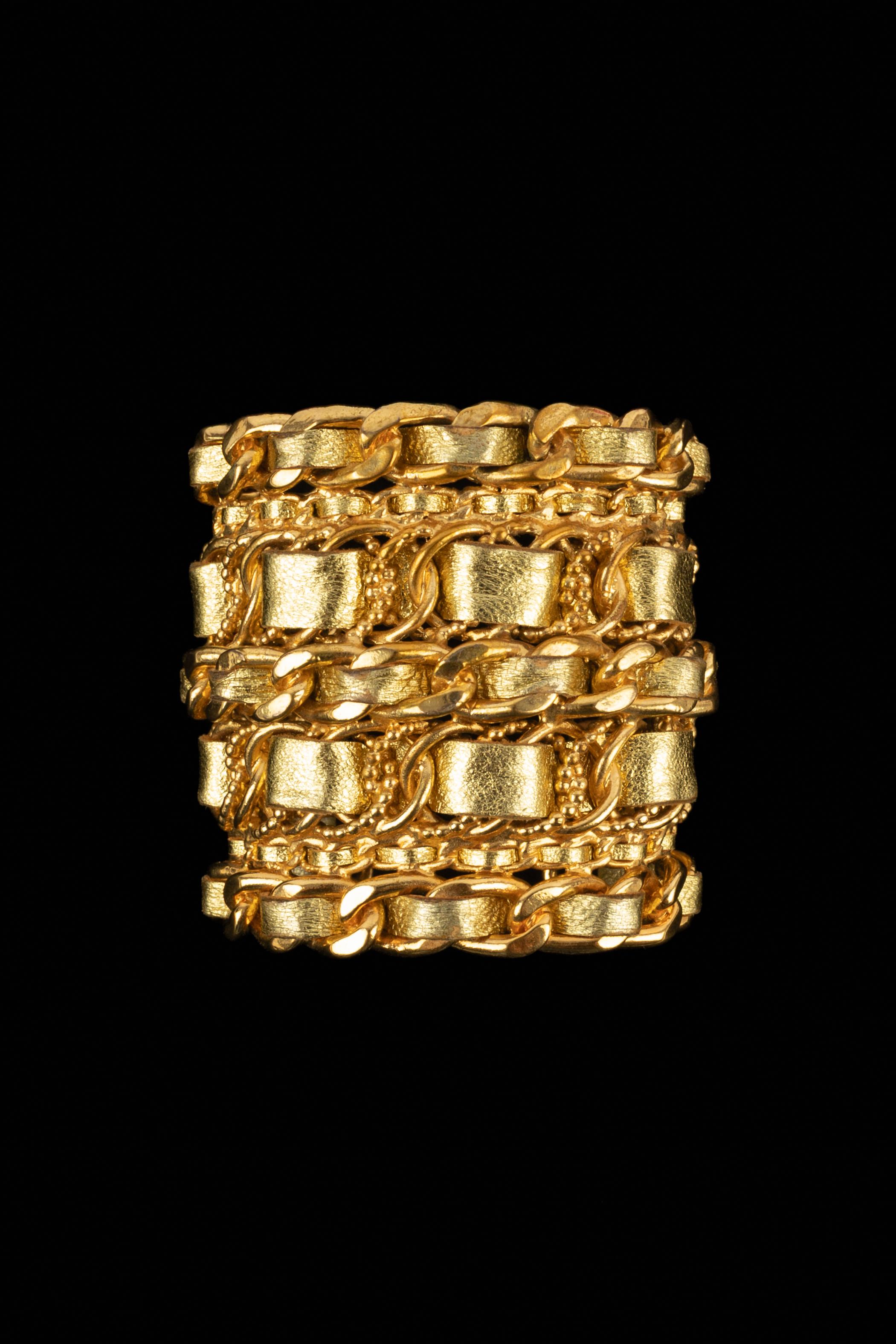 CHANEL - (Fabriqué en France) Bracelet manchette en métal doré et cuir doré. A 2cc6 Collectional, sous la Direction artistique de Karl Lagerfeld.

Condit :
Très bon état.

Dimensions :
Tour de poignet : 13,5 cm - Ouverture : 3 cm - Longueur : 7