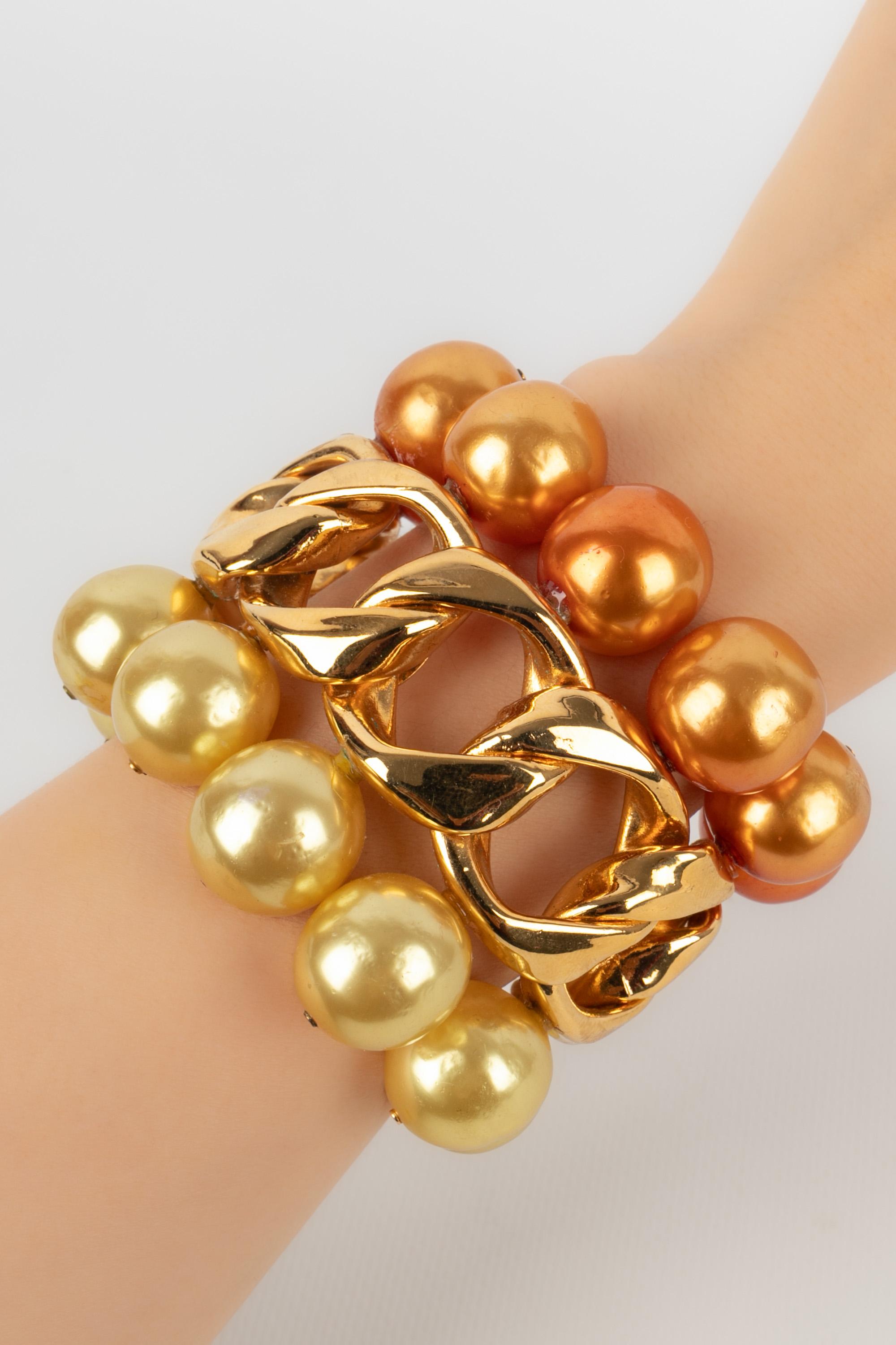 CHANEL - (Made in France) Golden metal cuff bracelet ornamented with yellow and orange costume pearls. 2cc5 Collection - 1991 Collection.

Condition:
Very good condition

Dimensions:
Wrist circumference: 15 cm - Opening: 3 cm - Length: 7 cm

BRAB157
