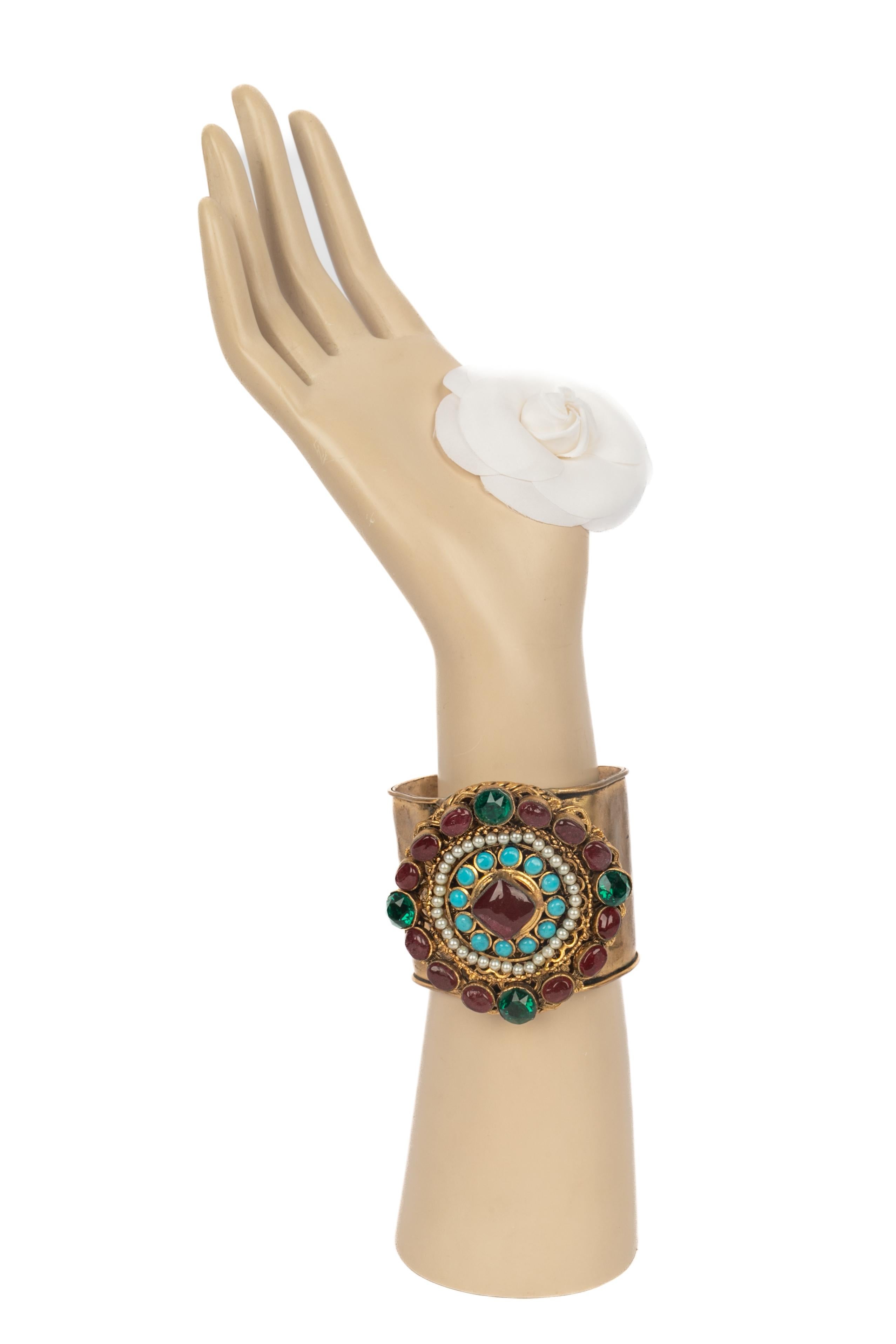 CHANEL - Geschlagenes goldenes Metallarmband mit Strasssteinen, Kostümperlen und Glaspaste. Eine Collection'S aus der Zeit von Coco.

Bedingung:
Guter Zustand

Abmessungen:
Länge: 15 cm - Öffnung: 3 cm

SKU:BRAB36