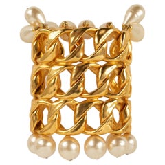 Brazalete Chanel de metal dorado, perlas de fantasía y gotas nacaradas