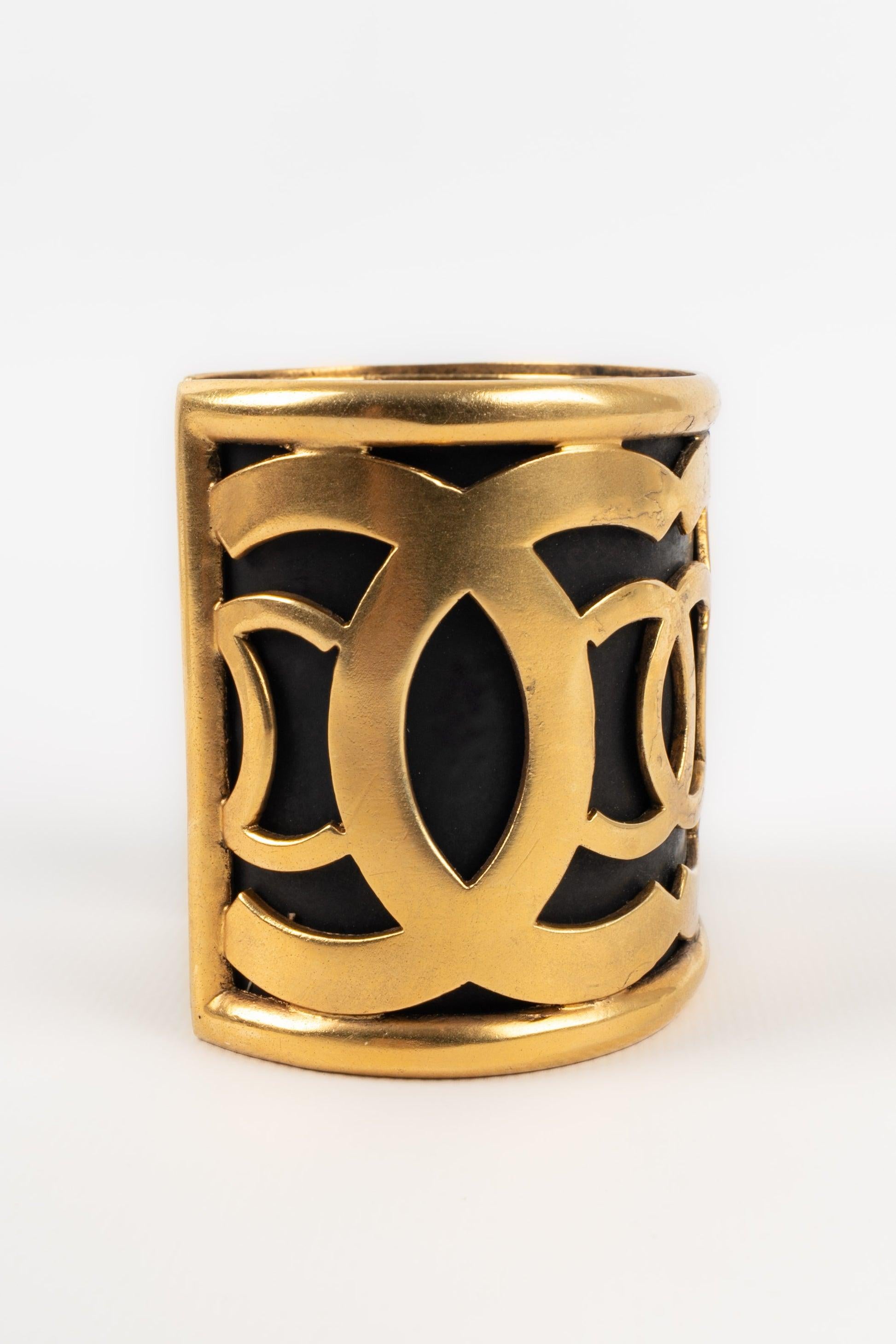 Chanel Manschettenarmband aus goldenem Metall auf schwarzem Hintergrund im Angebot 1