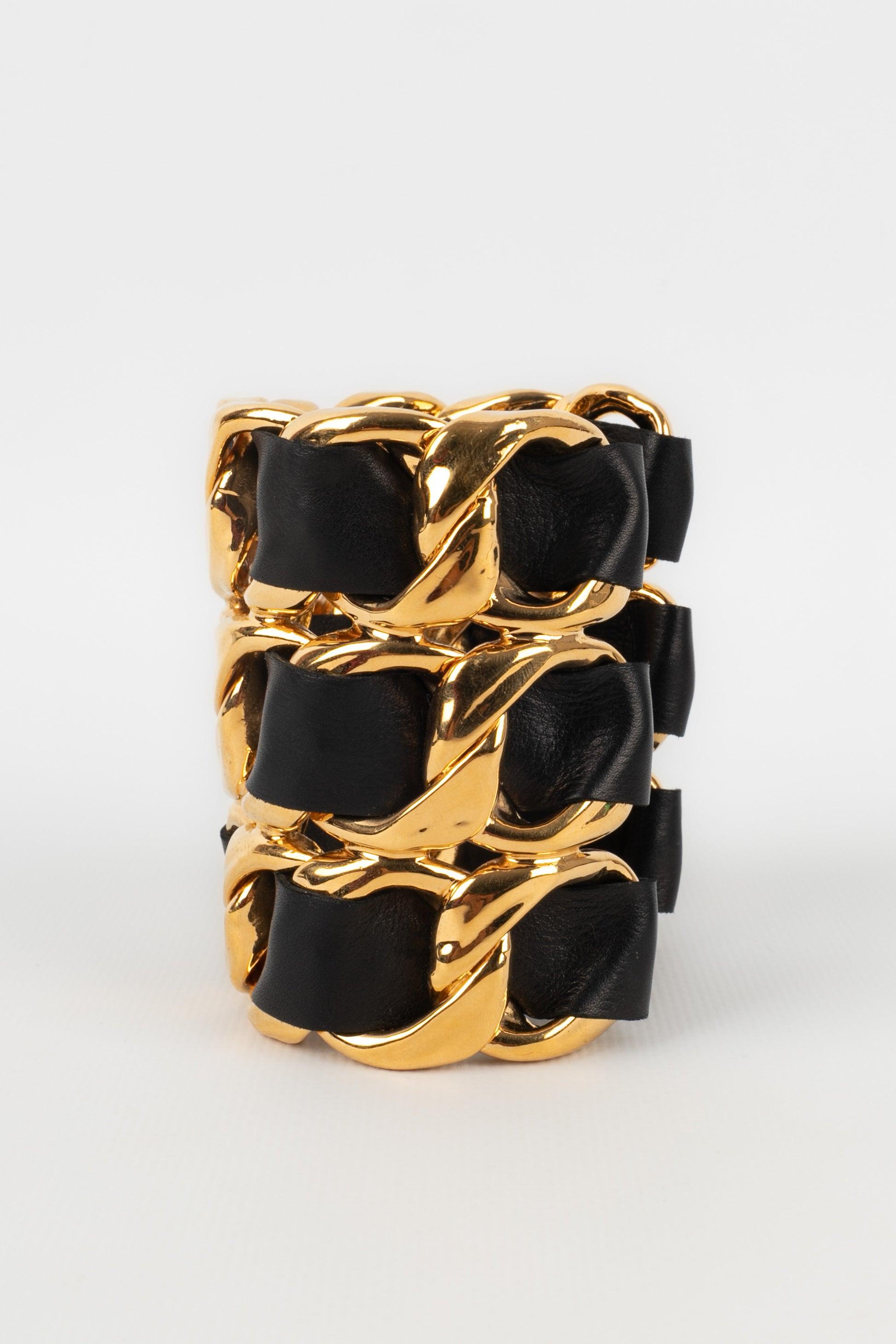 Chanel - (Made in France) Golden metal cuff bracelet with black leather. 2cc3 Collection - from the end of the 1980s.

Additional information:
Condition: Very good condition
Dimensions: Wrist circumference: 14 cm - Opening: 3 cm - Height: 8