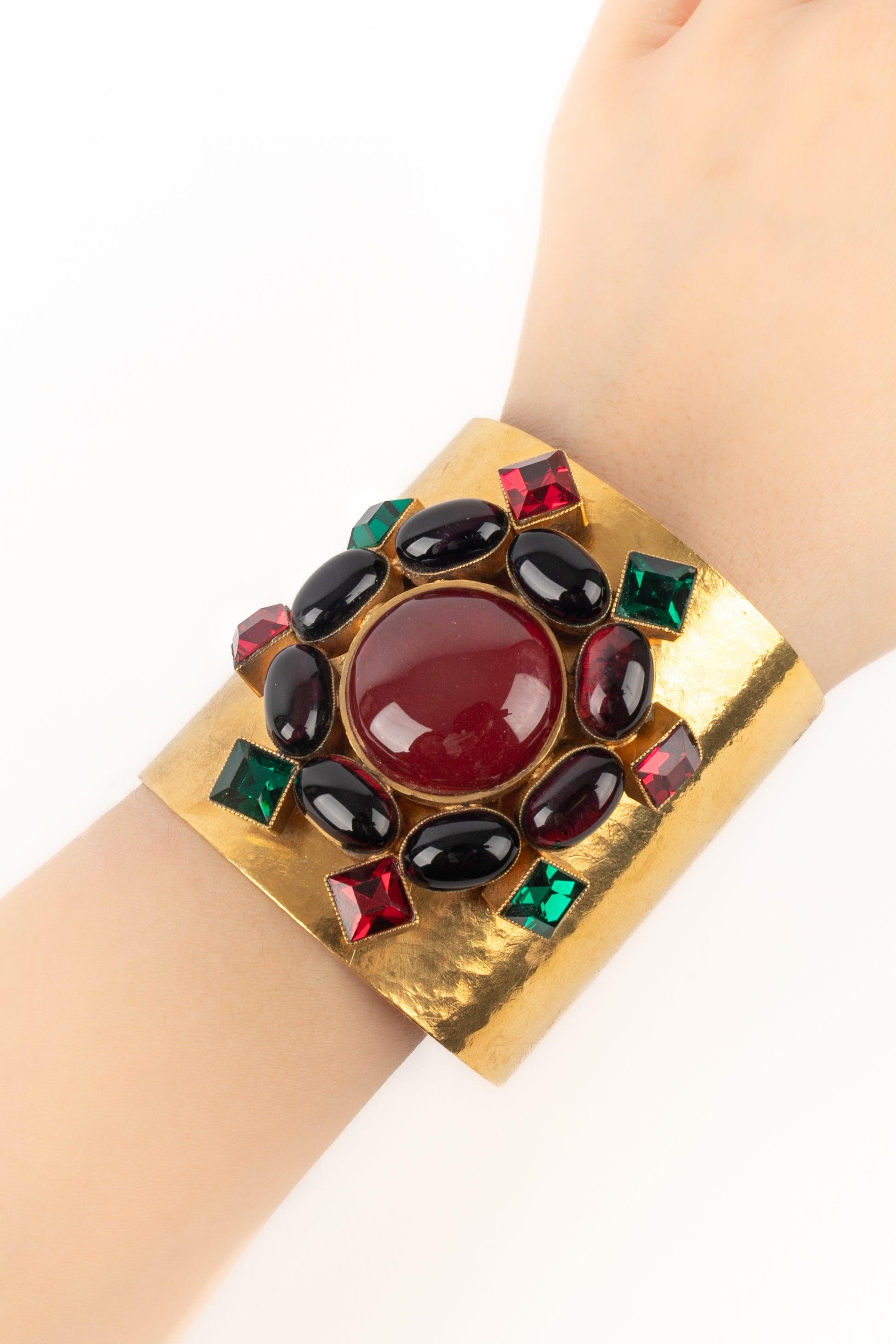 Chanel - (Fabriqué en France) Bracelet manchette en métal battu doré orné de pâte de verre. Collectional automne-hiver 1996, sous la direction artistique de Karl Lagerfeld.

Informations complémentaires :
Condit : Très bon état.
Dimensions :
