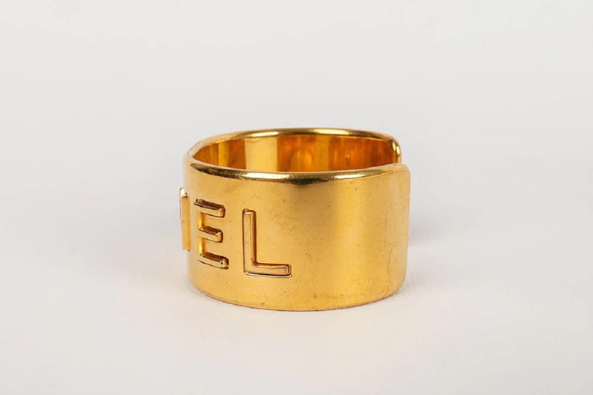 Chanel -(Made in France) Cuff in gold metal. Fall-Winter 1997 collection. Presence of scratches on the metal.

Additional information:

Dimensions: 
Circumference: 14 cm 
Opening: 3 cm, Width: 3 cm

Condition: Good condition

Seller Ref number: