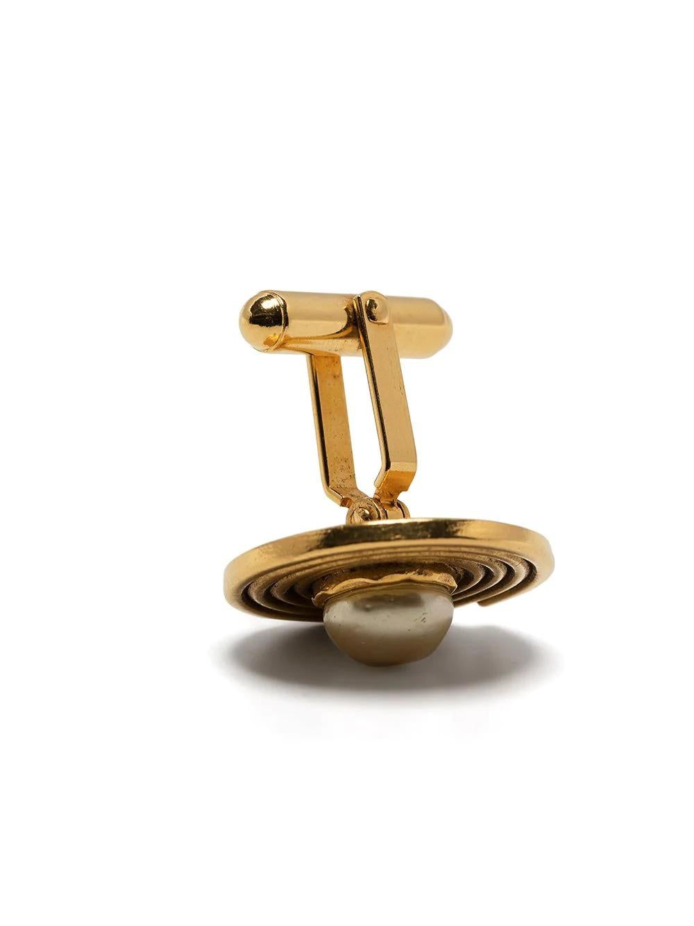 A must-have piece in any vintage designer lovers collection. These pre-owned Chanel cufflinks feature a gold-plated metal swirl with a central faux pearl. The perfect addition to your work outfit, pop through the cuffs of your favourite white shirt