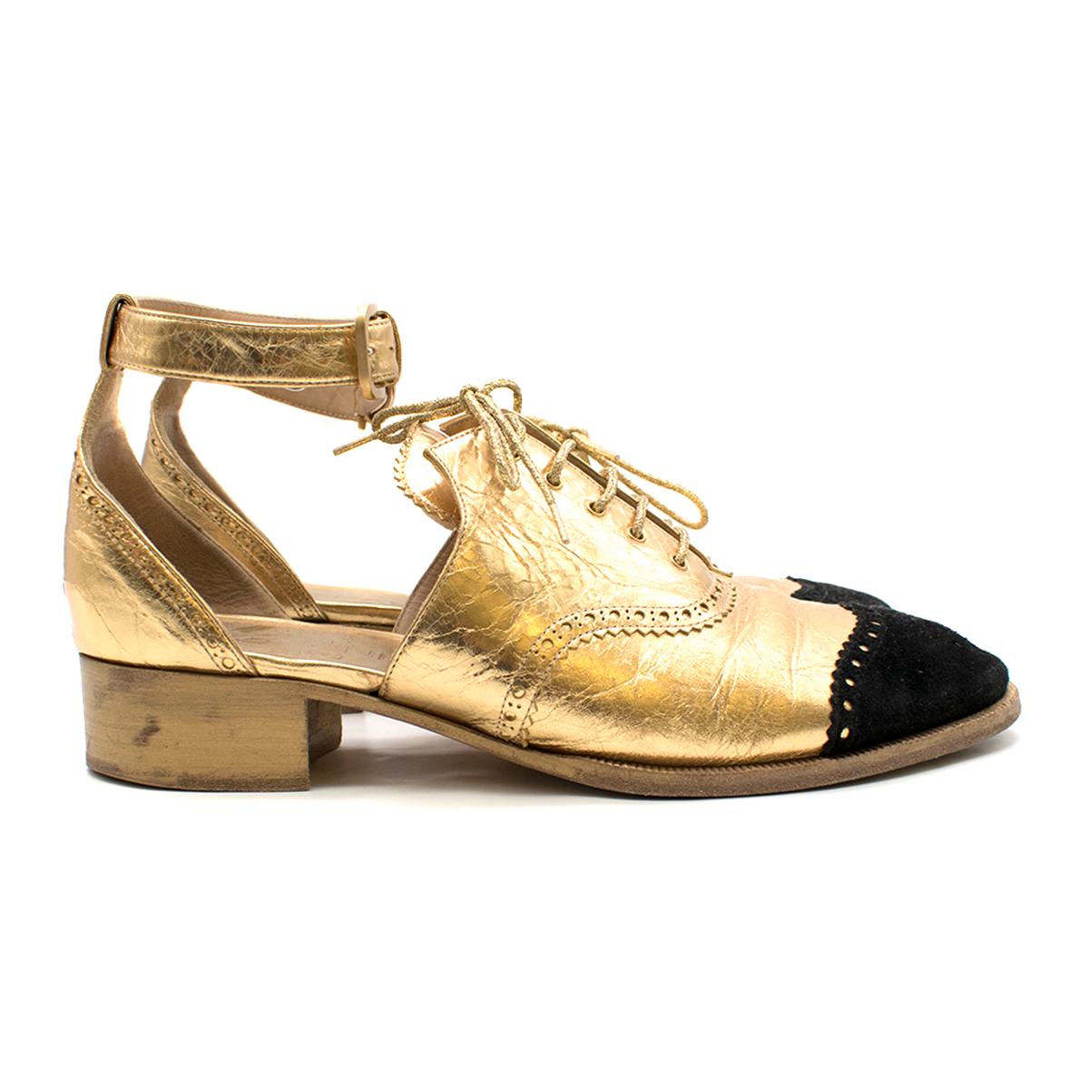 Chanel cut-out gold leather brogues 

- Gold, leather 
- Round toe, small stacked leather heel 
- Classic wingtip brogue detailing 
- Black suede toe cap, perforated CC
- Cutout feature 
- Gold lace-up front 
- Gold leather insole, nude leather